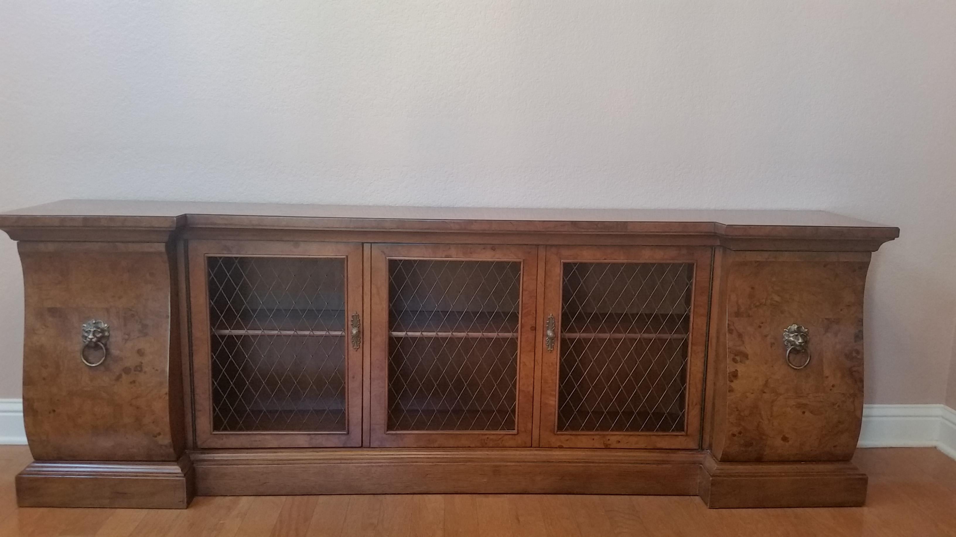 Handmade in America by the venerable Tomlinson Furniture Company, this burled walnut console/credenza/bookcase was designed originally for limited production. Today, it is a rare heirloom find. 

Overall, the piece has a warm rich luster and