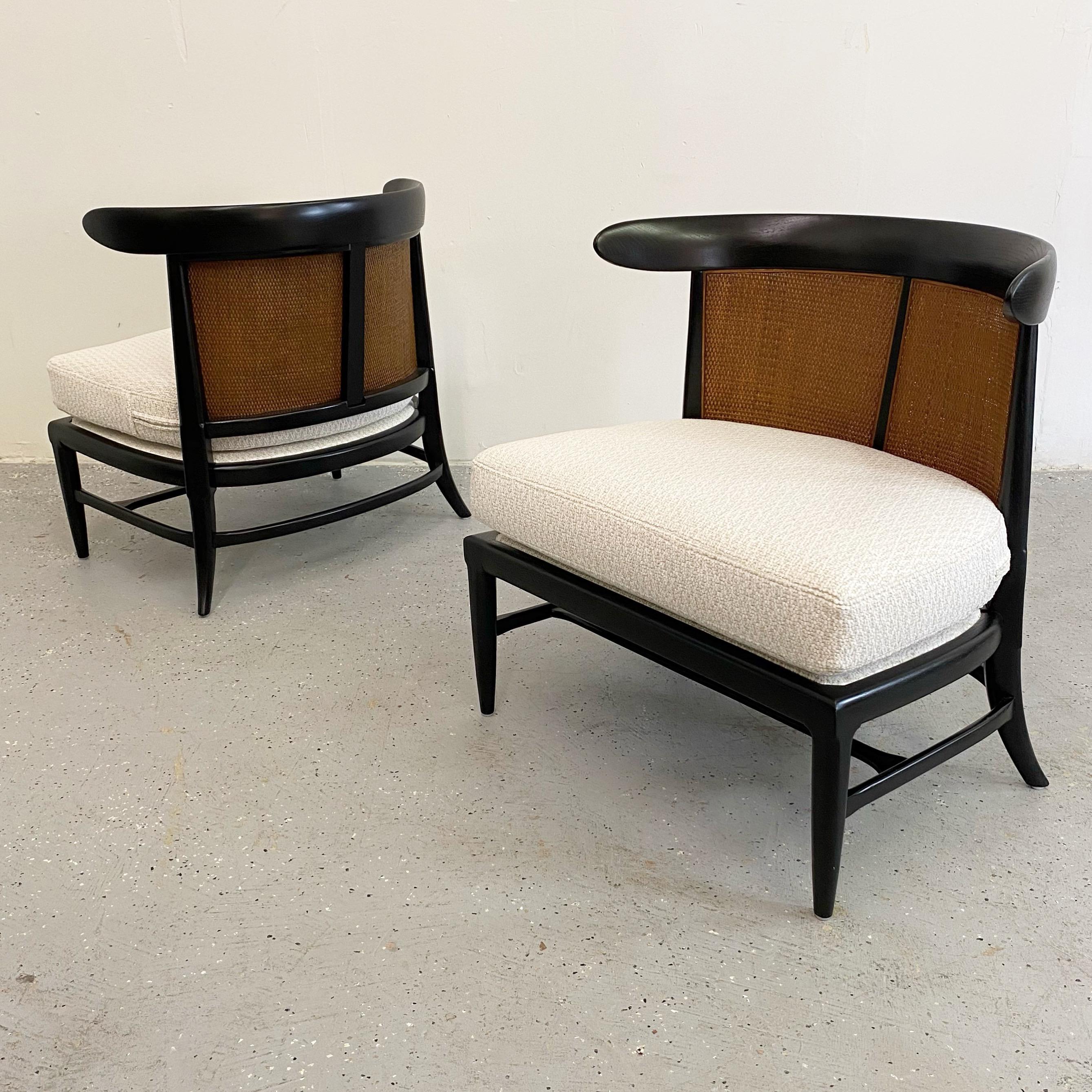 An incredible pair of vintage slipper chairs in excellent restored condition. These have been rejuvenated with a satin black lacquer to contrast the original cane. New boucle upholstery tops off the sculpted frames. A beautiful vintage pair ready to