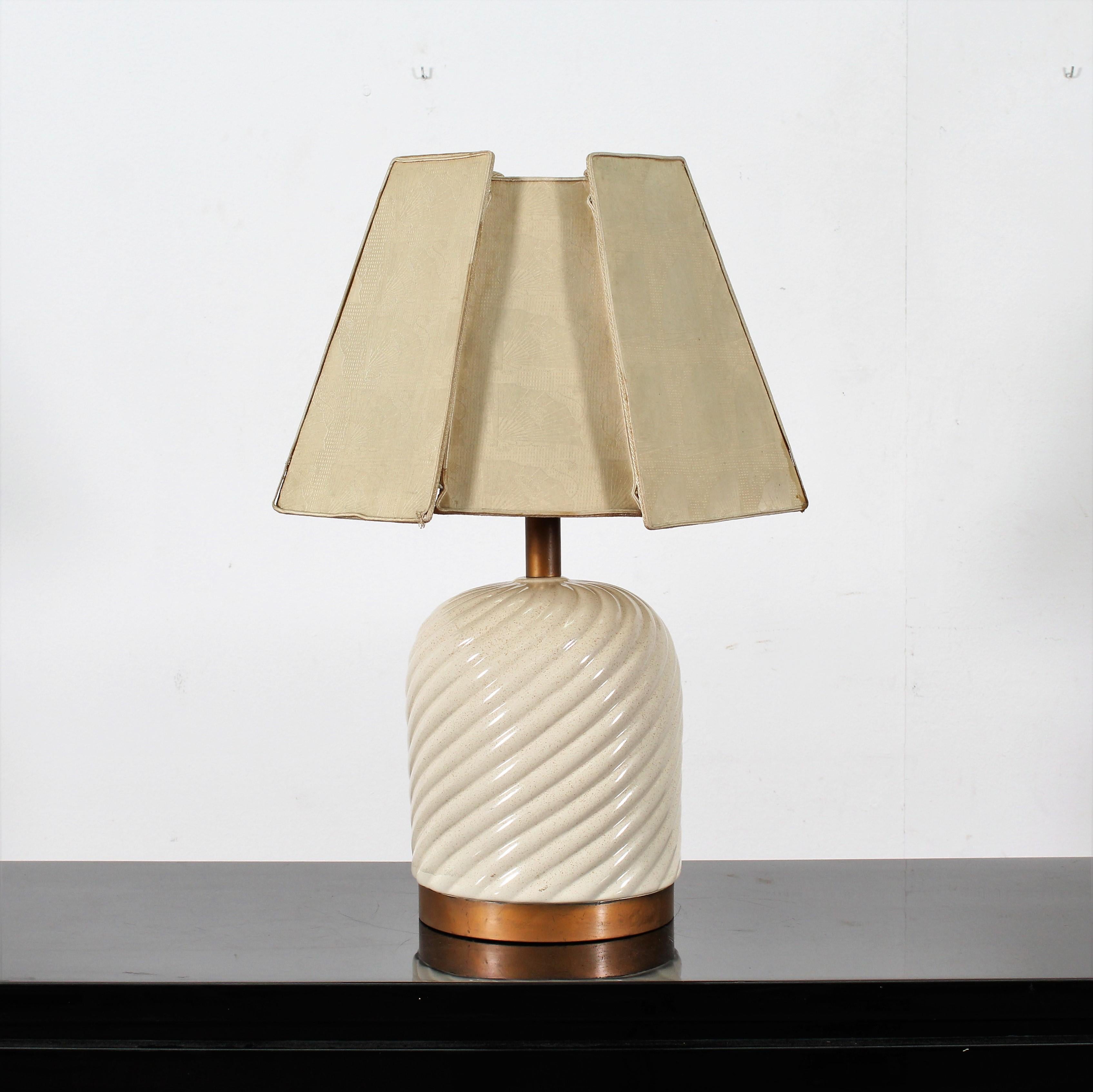 Table lamp designed by Tommaso Barbi and manufactured in Italy in 1970. The piece features a spiral ceramic structure with a brass base, fabric shade, and the manufacturers mark and label to the internal section.
Wear consistent with age and use.