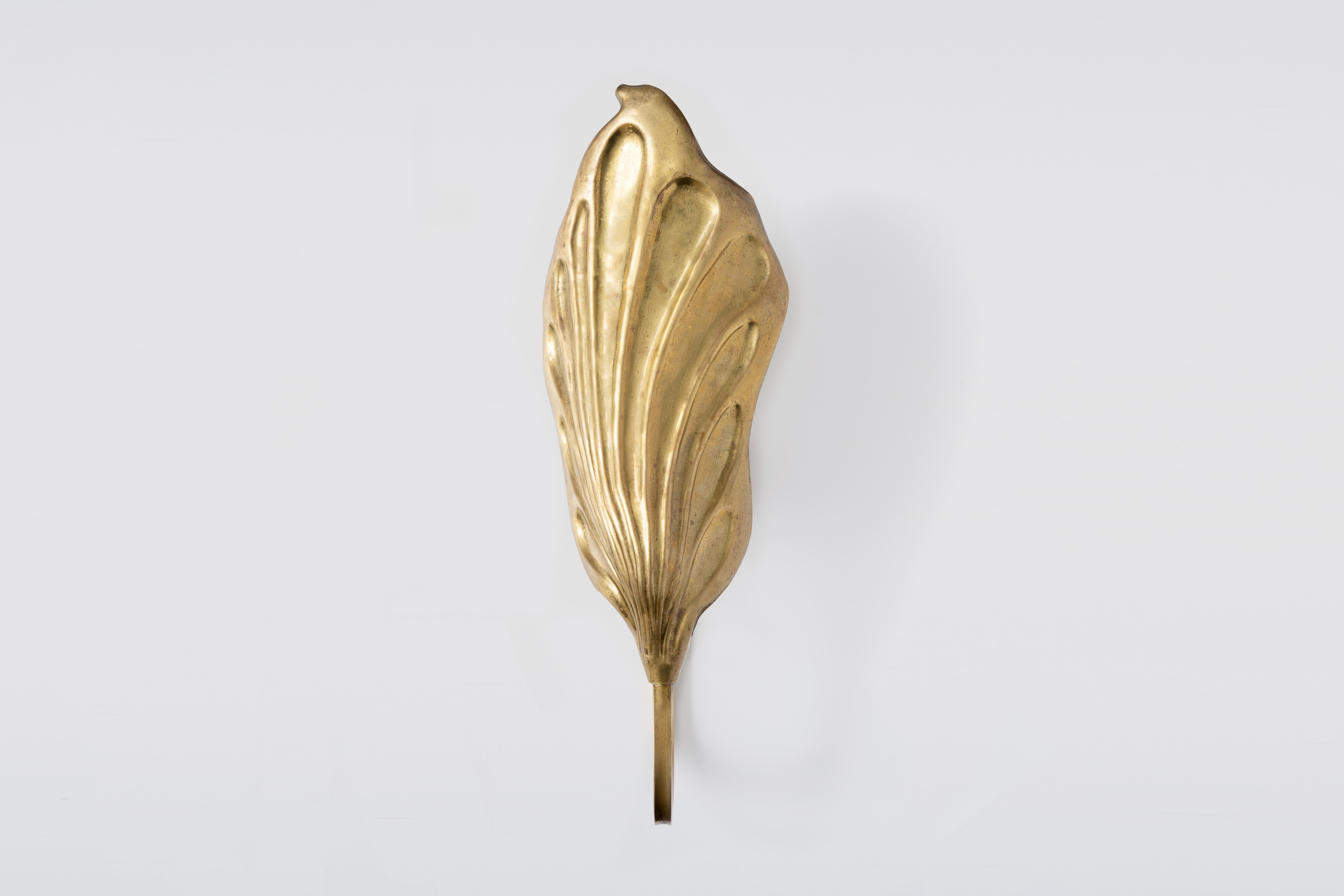 This gold brass sconce by Tomasso Barbi from the 1970s perfectly captures his iconic style. The wall structure elegantly supports a leaf-shaped lampshade, reflecting Barbi's flair for nature-inspired designs. The intricate detailing of the leaf