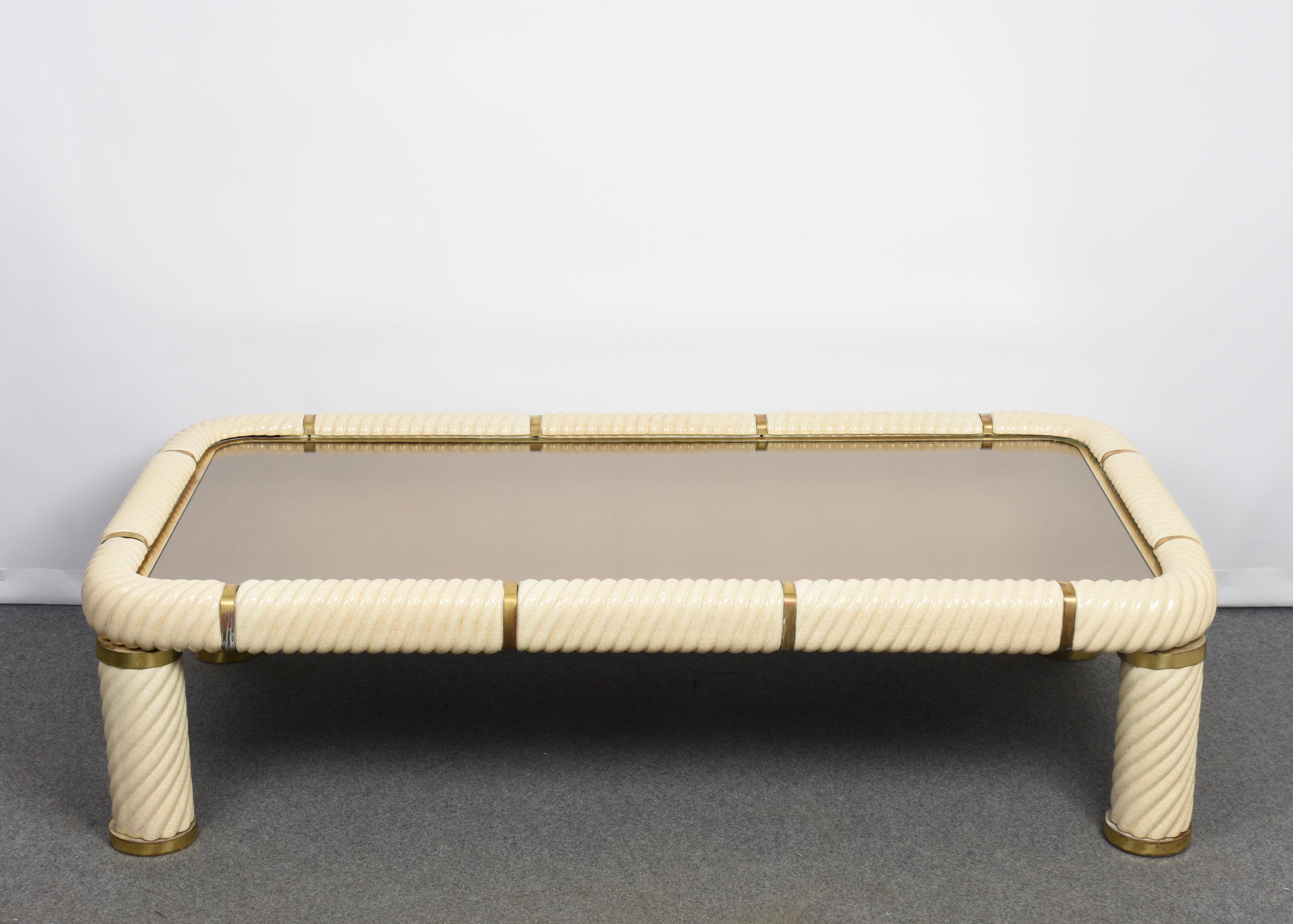 Amazing midcentury Hollywood Regency style ceramic brass and mirrored glass coffee table. This wonderful item was designed in Italy during the 1970s and designed by Tommaso Barbi.

This remarkable piece features spiral-form ceramic porcelain
