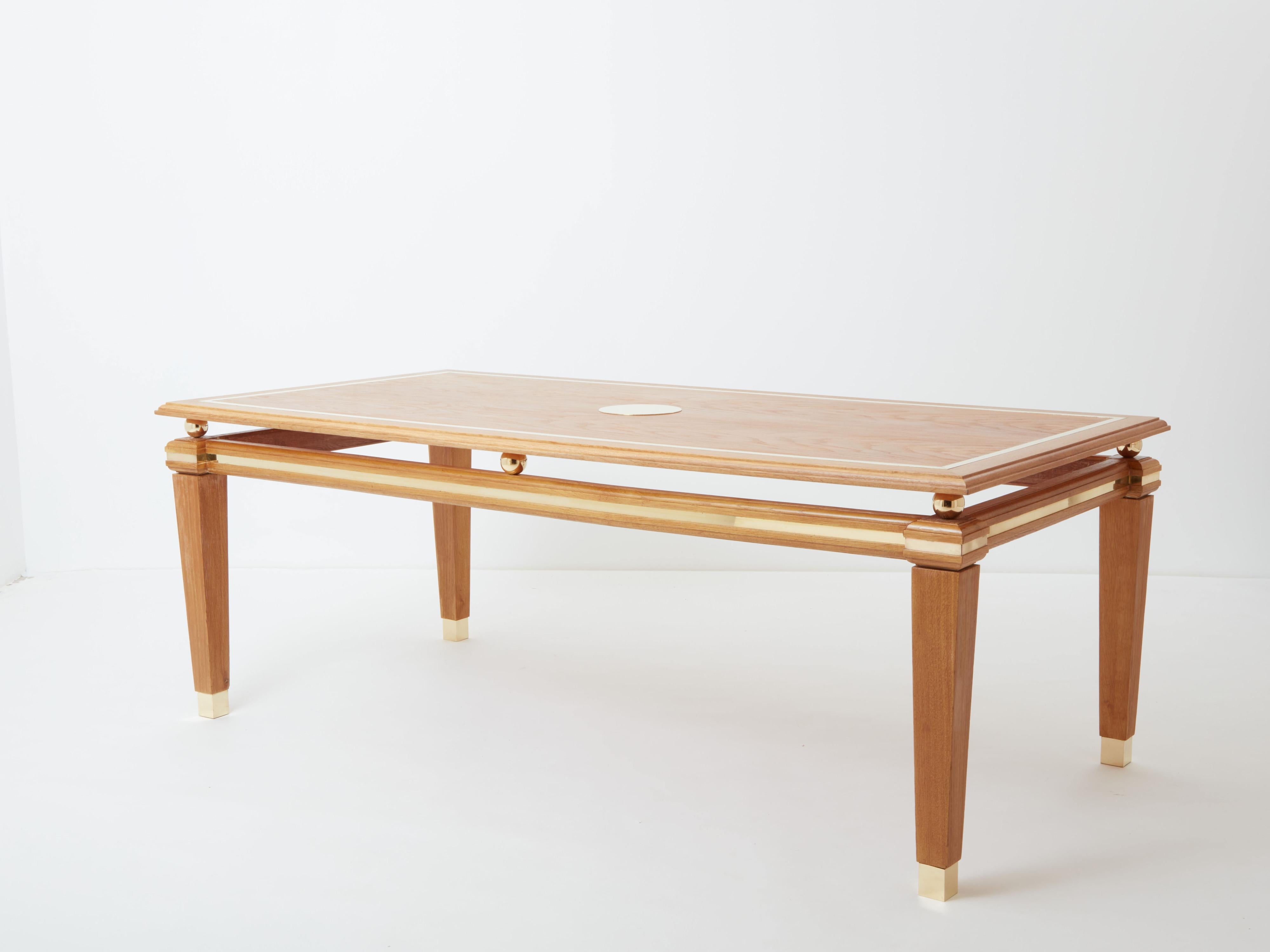 This beautiful cerused oak dining table was designed by Italian mid-century modern designer Tommaso Barbi in the 1970s. The top features a nice brass inlay frame, with a round raised brass piece to serve as a centerpiece. Six solid brass balls