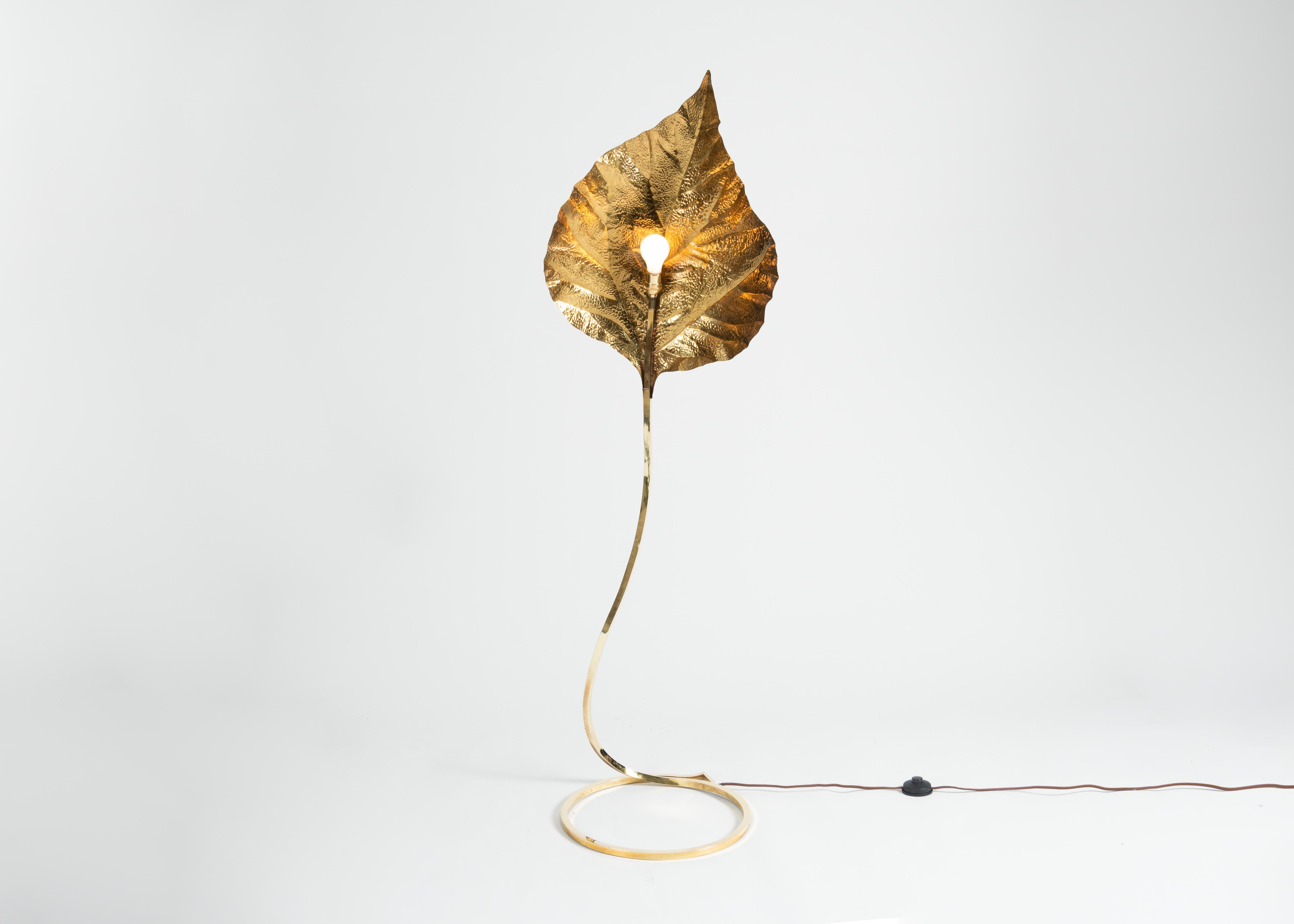 This extraordinary Italian floor lamp, a work of marvelous simplicity and elegance, is composed of brass, possesses a sinuous, elegant base, and features a show-stopping shade modeled perfectly after a broad, slightly folding leaf.