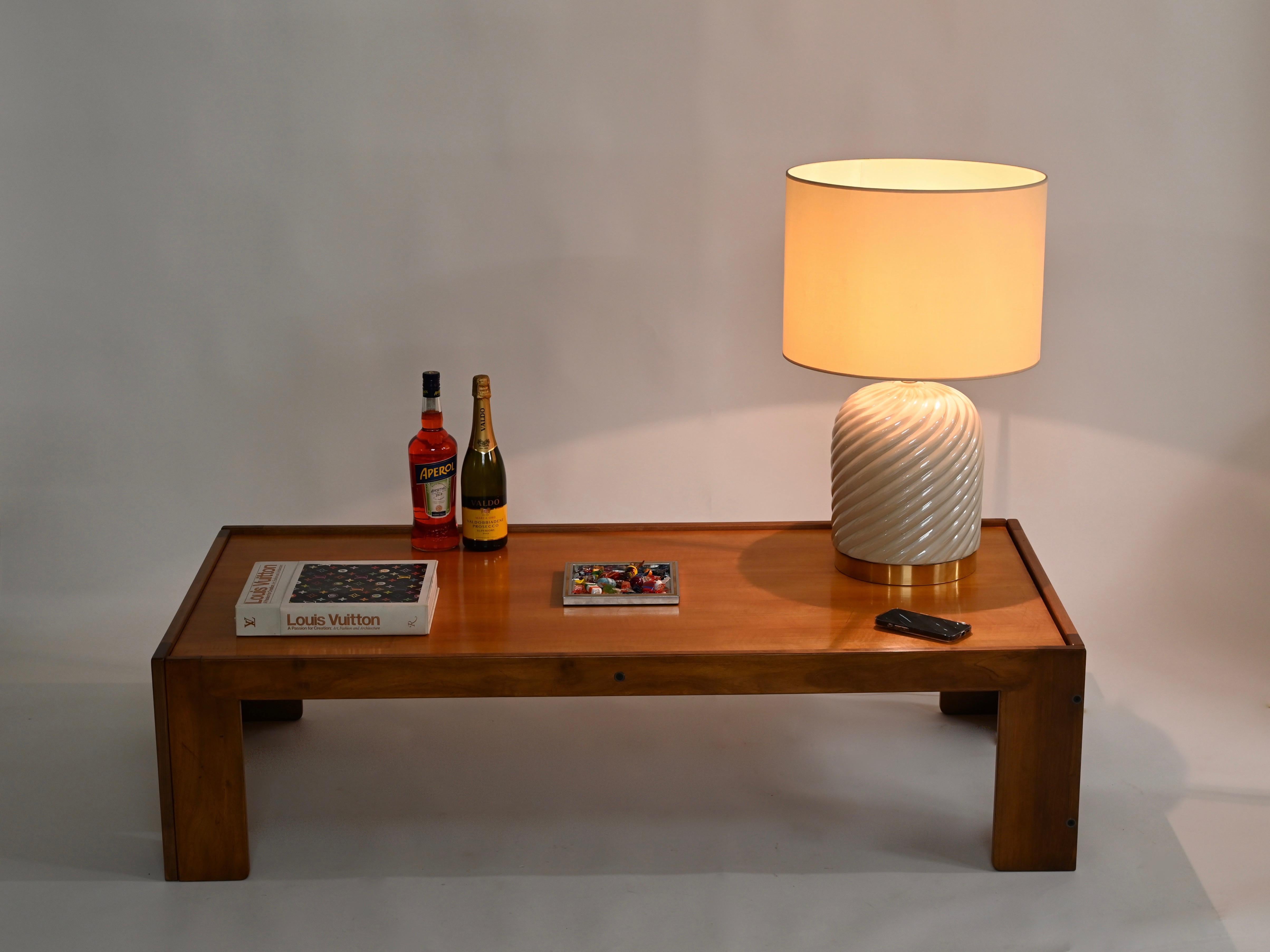 Superbe lampe de table ronde du milieu du siècle, en céramique crème et laiton. Cette lampe emblématique a été conçue par Tommaso Barbi en Italie au début des années 1970 et est signée à l'intérieur. 

Cette lampe élégante a un corps rond en