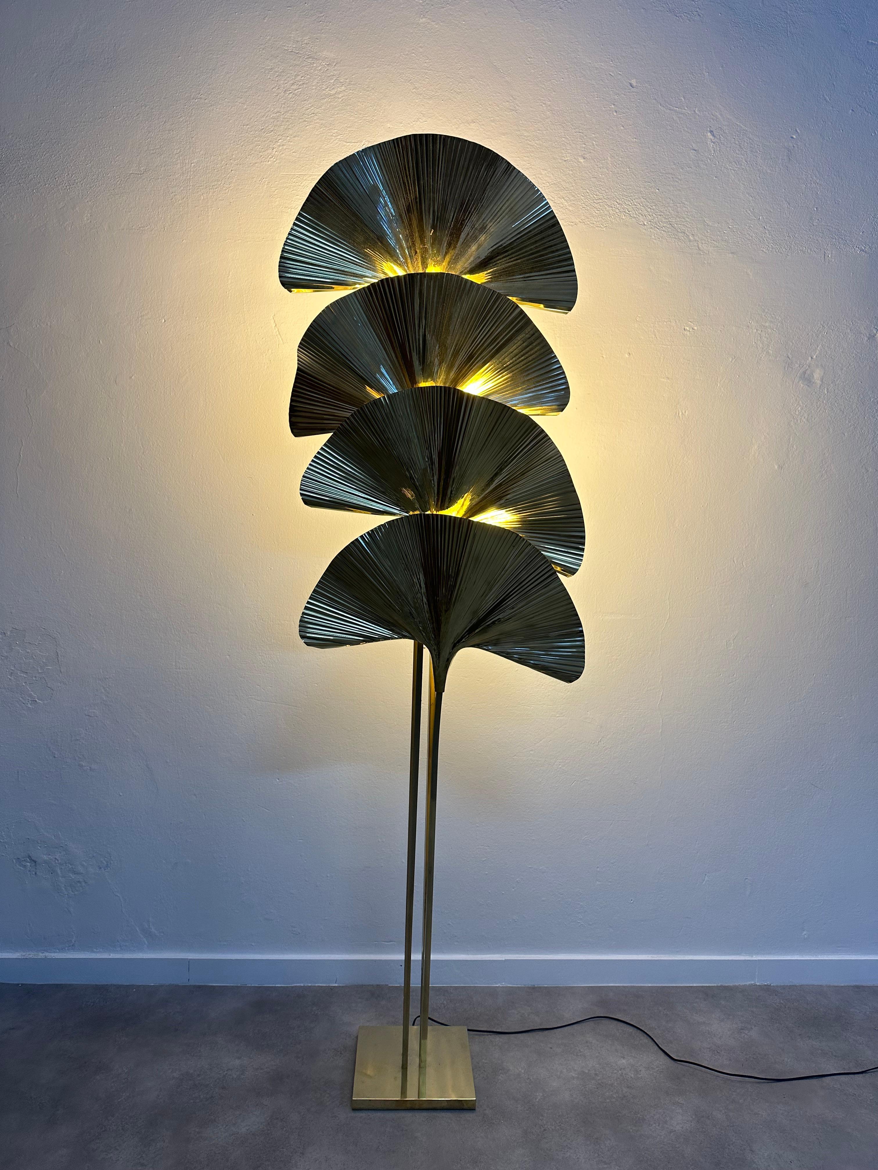 Stunning floor lamp after the design of Tommaso Barbi. Three large brass ginkgo leaves, each leaf conceals a light source. In excellent condition.
    