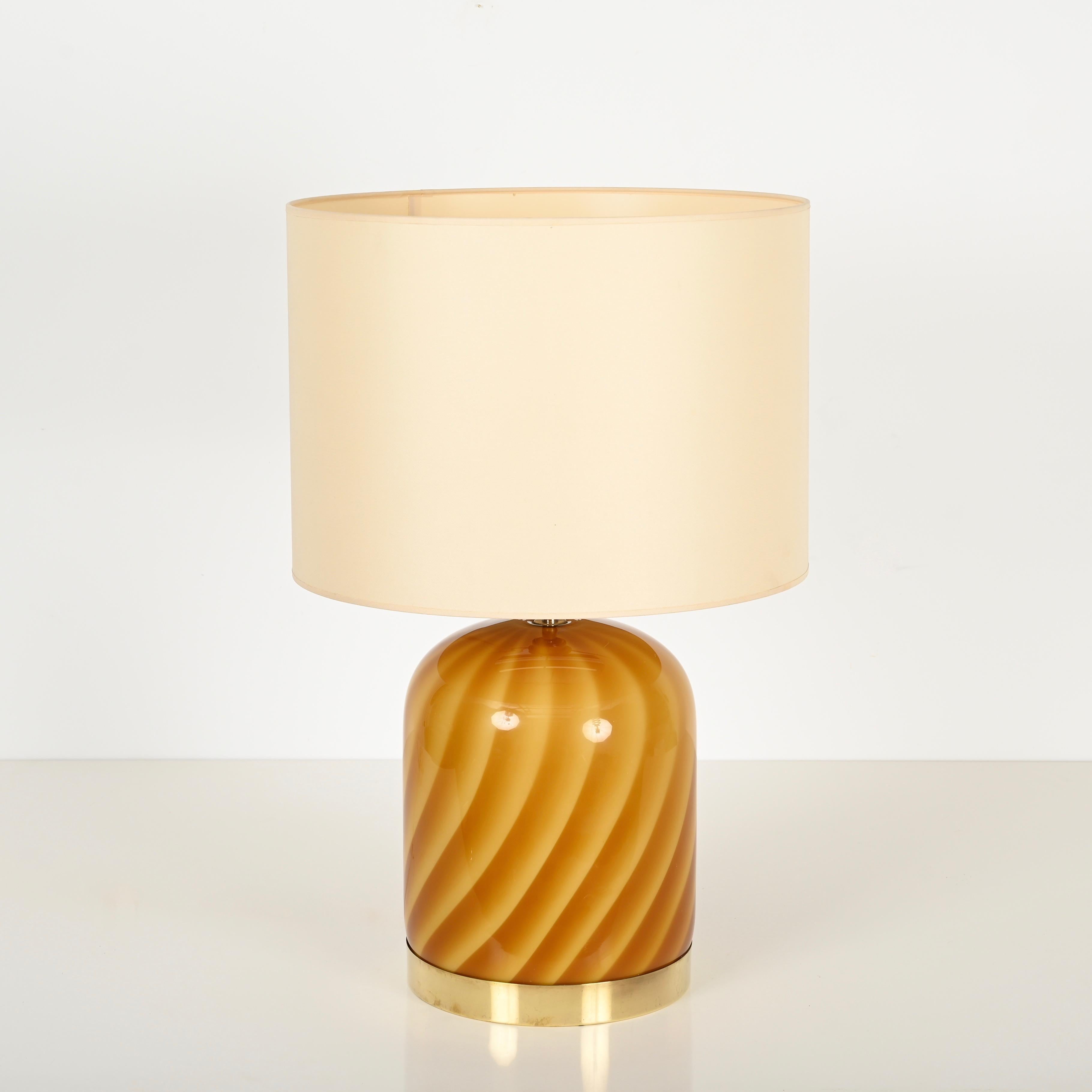 Magnifica lampada da tavolo della metà del secolo scorso in vetro soffiato a bocca di Murano giallo e arancione e ottone. Questa lampada incredibilmente rara ed elegante è stata disegnata da Tommaso Barbi e prodotta negli anni Sessanta. La lampada è