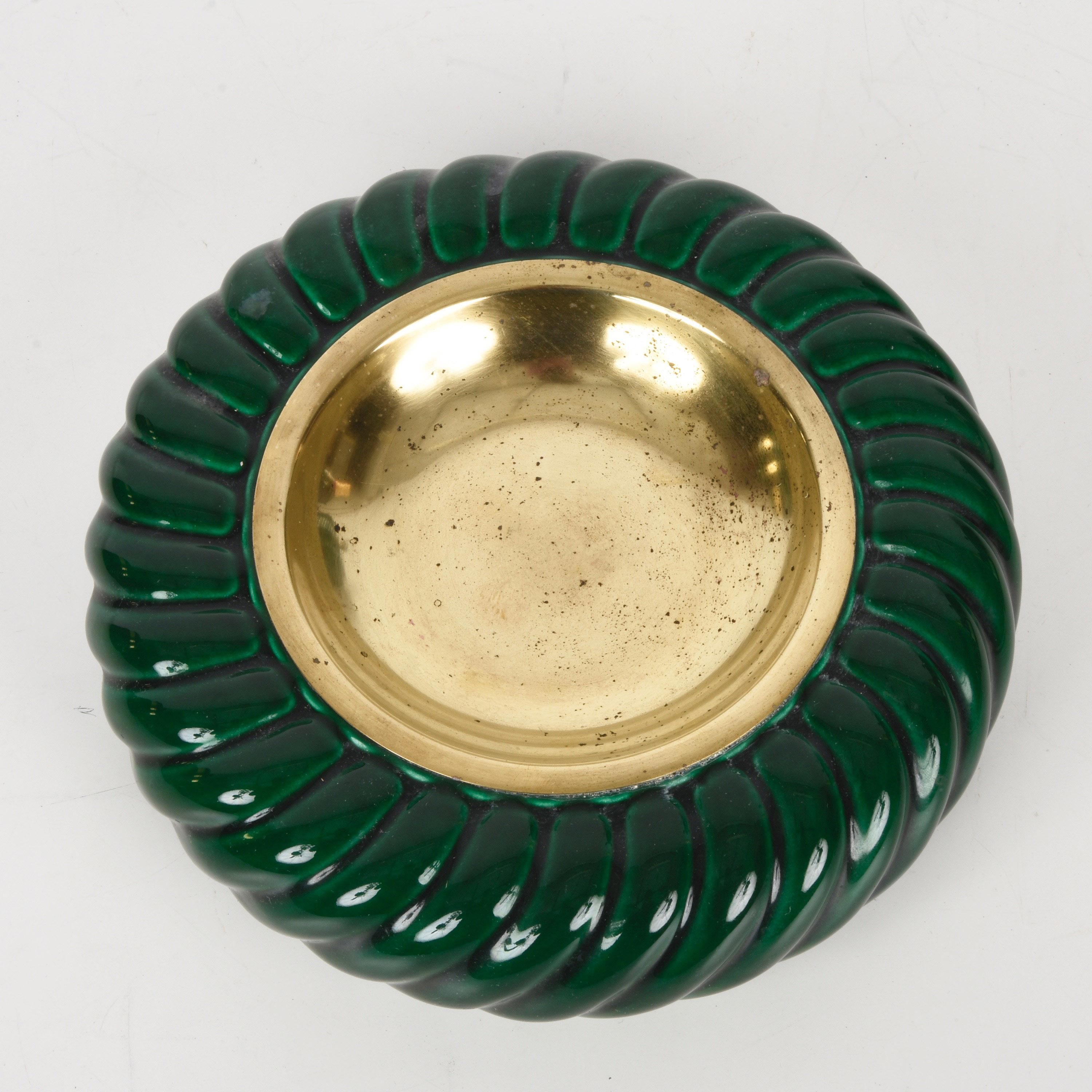 Amazing Mid-Century Modern green ceramic and brass ashtray. This fantastic piece was designed by Tommaso Barbi and produced by B. Ceramiche during the late 1960s in Italy.

The brand of the manufacturer is at the bottom part of the item while on