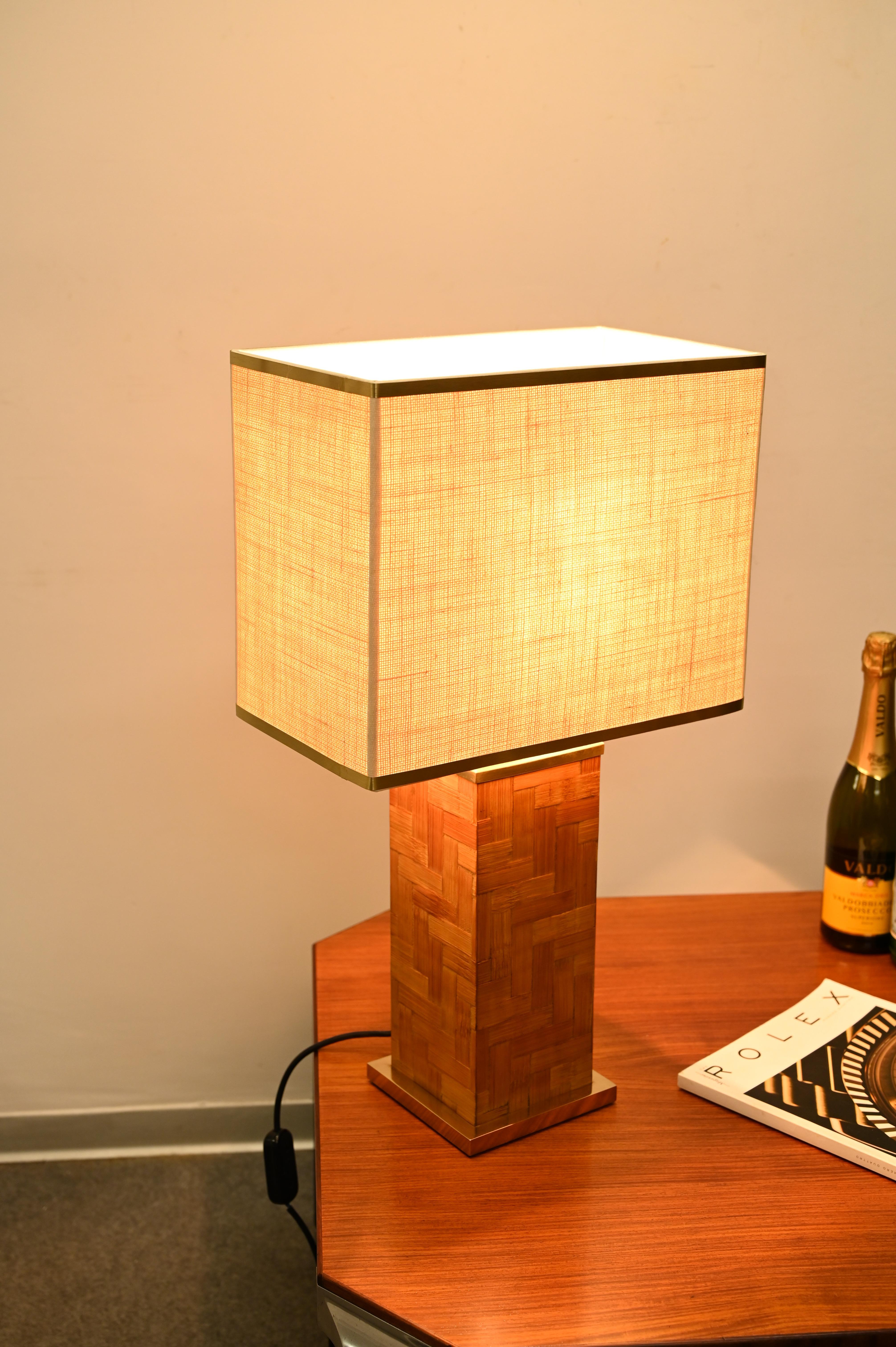 Wunderschöne quadratische Tischlampe aus Messing und Rattan, die in hervorragender Verarbeitung hergestellt wurde. Die wunderschöne Lampe wurde in den 1970er Jahren von Tommaso Barbi in Italien hergestellt.

Die Lampe hat einen quadratischen Sockel