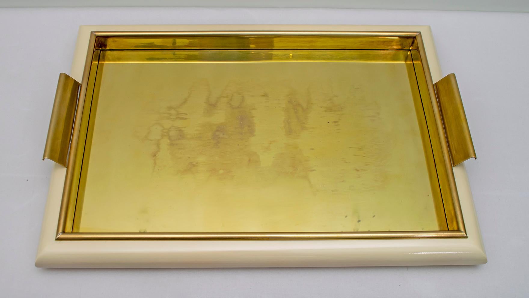 Tommaso Barbi serving tray produced in Italy in the 1970s
Structure in lacquered wood with an internal frame in edged brass, the support surface is composed of a brass plate protected by a plexiglass panel.