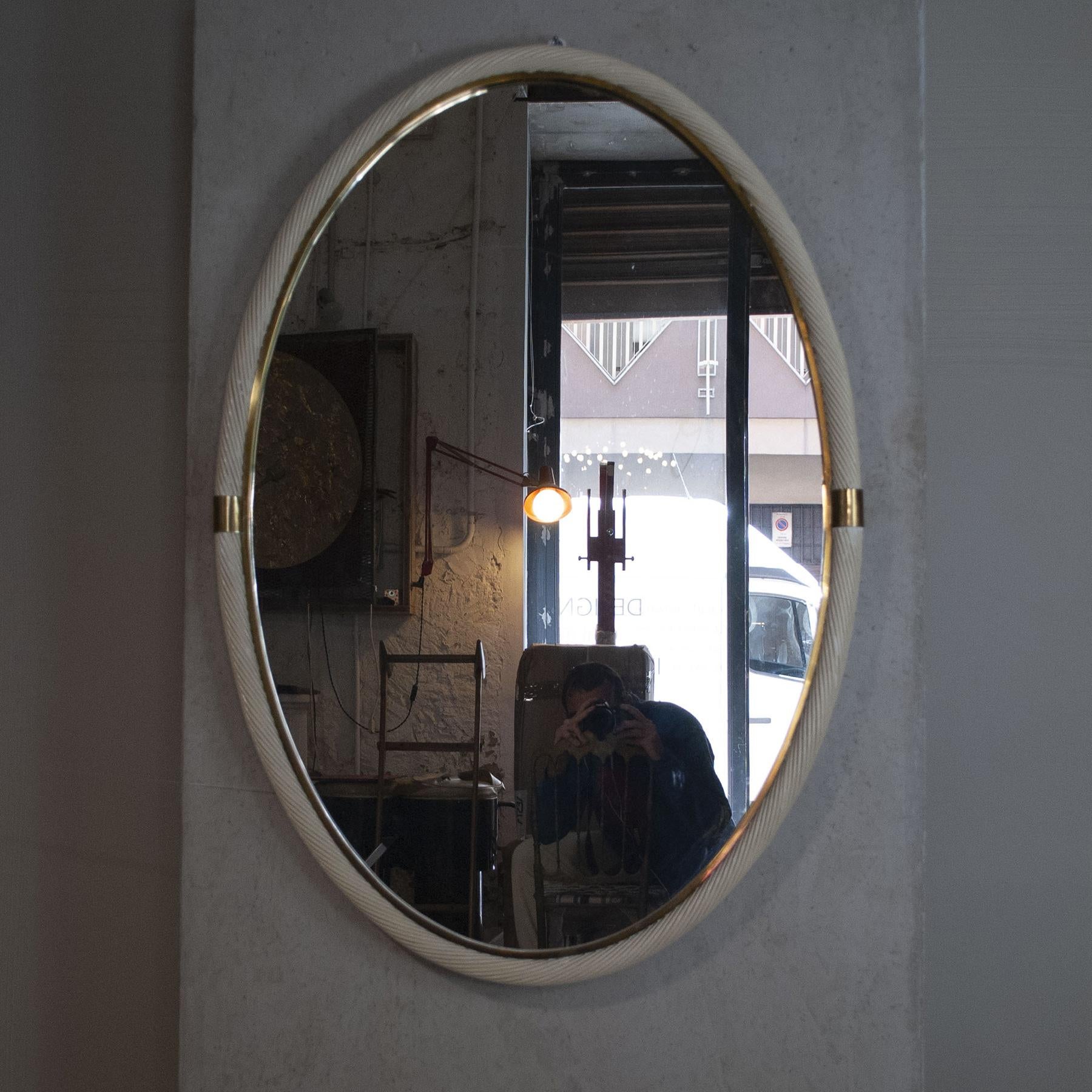 Splendide miroir de forme ovale, réglable en deux tailles, le cadre est en osier laqué et en laiton, il peut certainement être défini dans le style Tommaso Barbi.