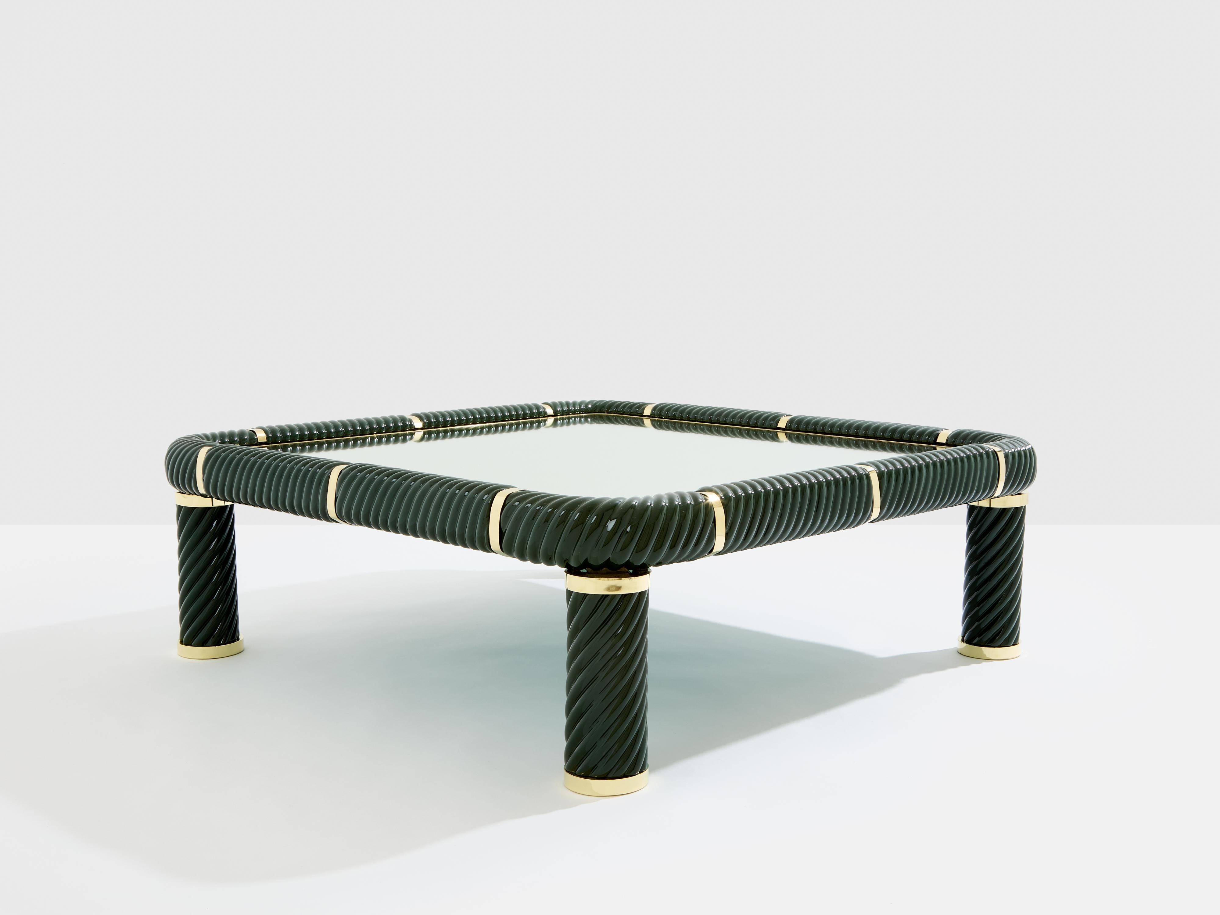 This beautiful olive green ceramic square coffee table was designed by Italian mid-century modern designer Tommaso Barbi in the 1970s. The structure features green torsade glazed ceramic pieces linked together by brass elements, finished by an inset