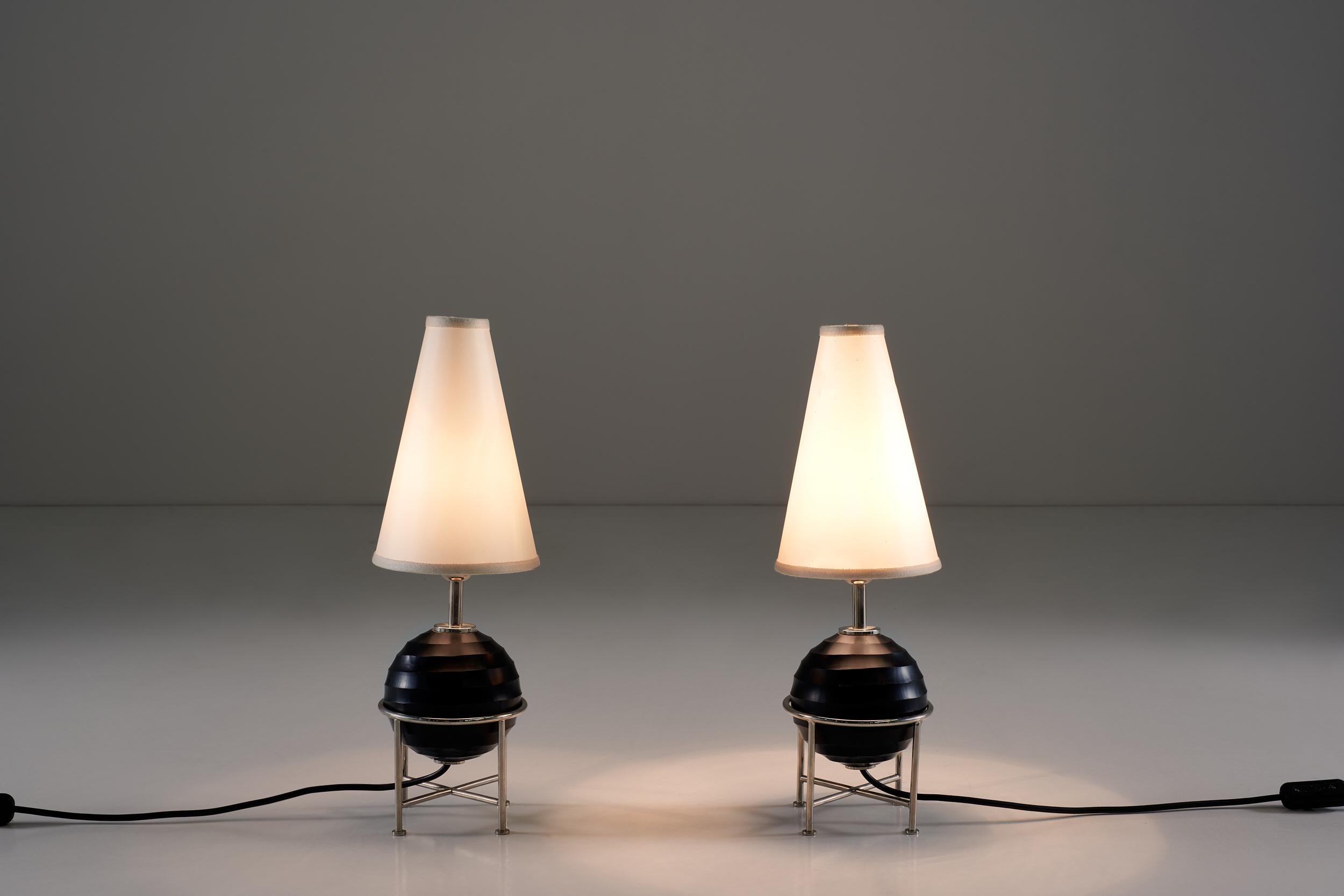 Diese Lampen vereinen Funktionalität und harmonische Linien auf eine neue, elegante Art und Weise, dank des schwarzen Glaskörpers, der Stahlstützen und der Lampenschirme aus Stoff.