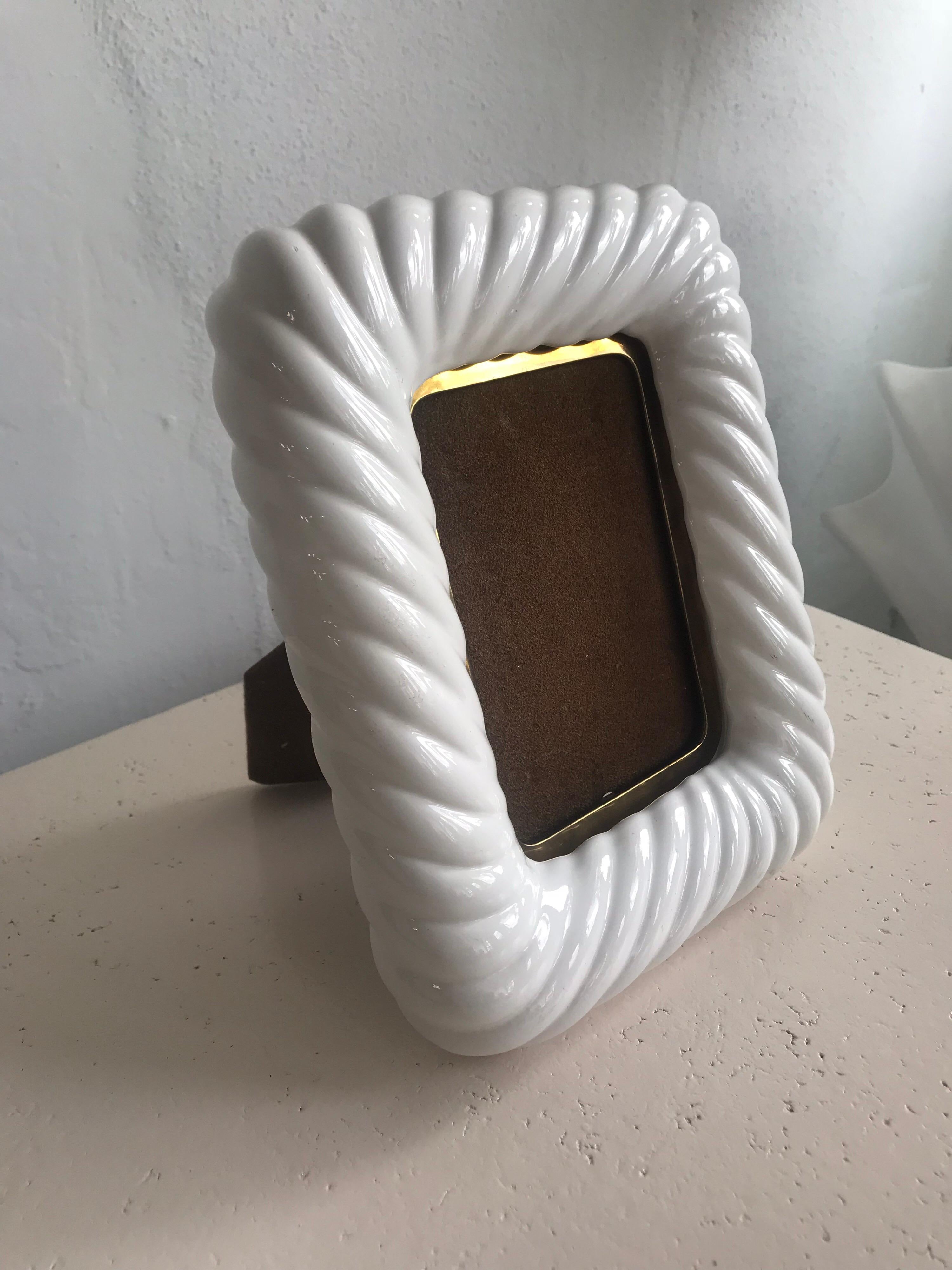 Picture or photo frame rendered in ivory glazed porcelain ceramic and patina brass designed by Tommaso Barbi, Italy, 1970s, Signed.

Fits a 4x6 photo.