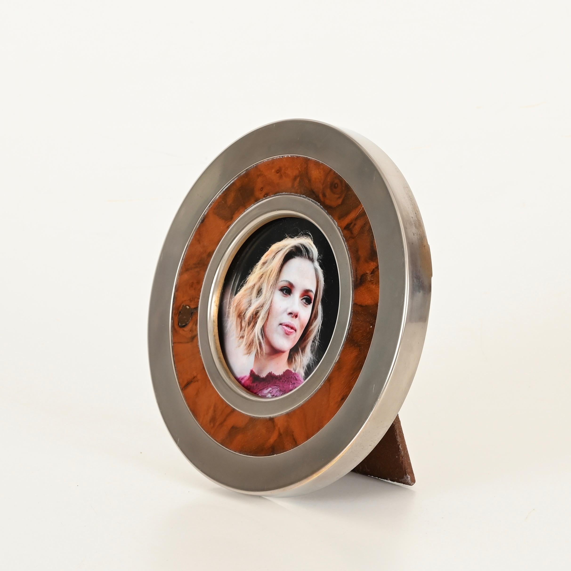 Wonderful midcentury photo frame in chrome-plated brass and burl. This incredibly stylish piece was designed by Tommaso Barbi and produced in Italy during the 1970s. The picture frame is signed on the back. 

In fantastic condition. This round photo