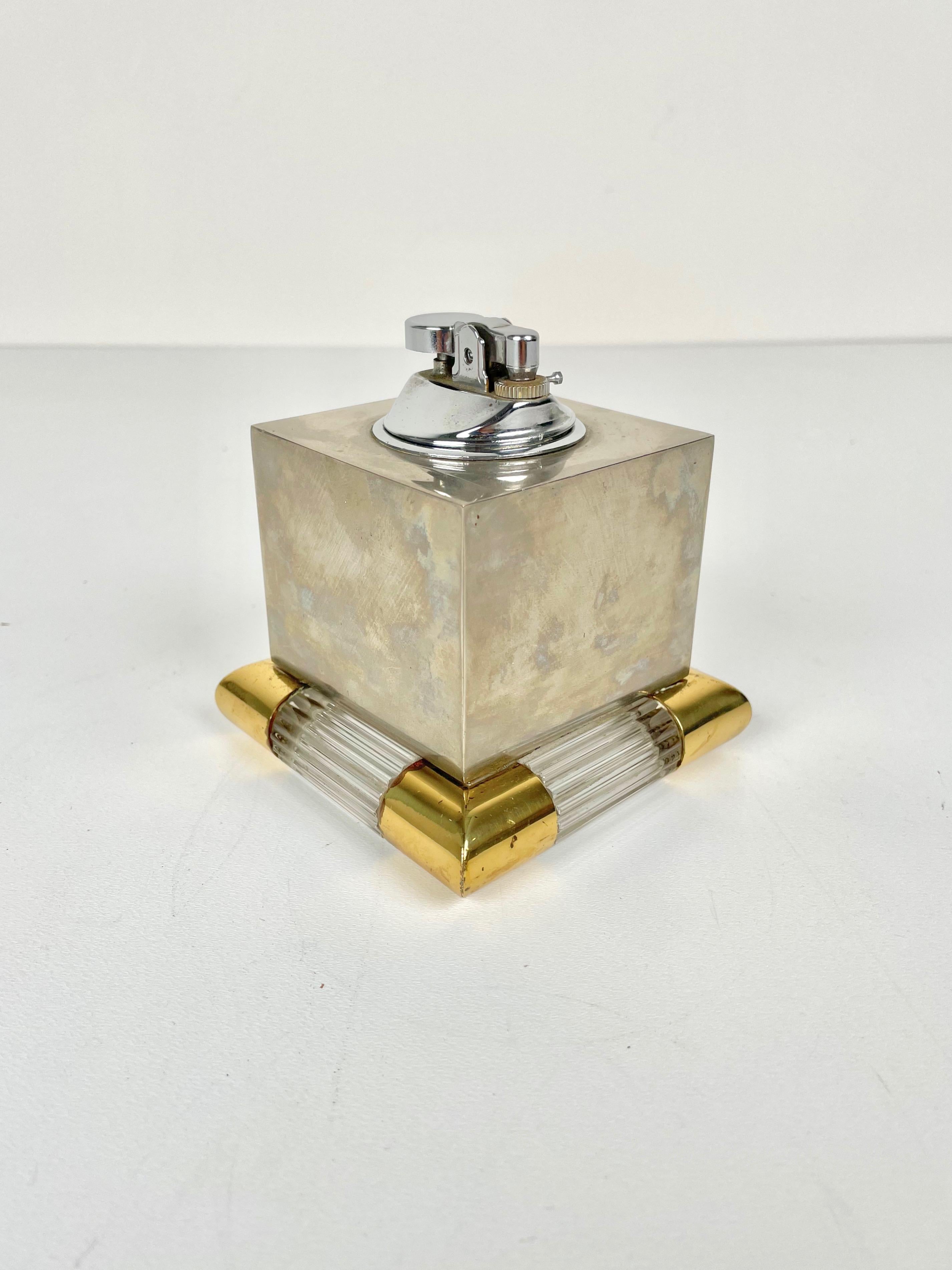 Elegant table lighter in steel featuring a Murano glass base with brass borders made by the Italian designer Tommaso Barbi in Italy in the 1970s. 

Tommaso Barbi's signature is engraved on the bottom together with the text 