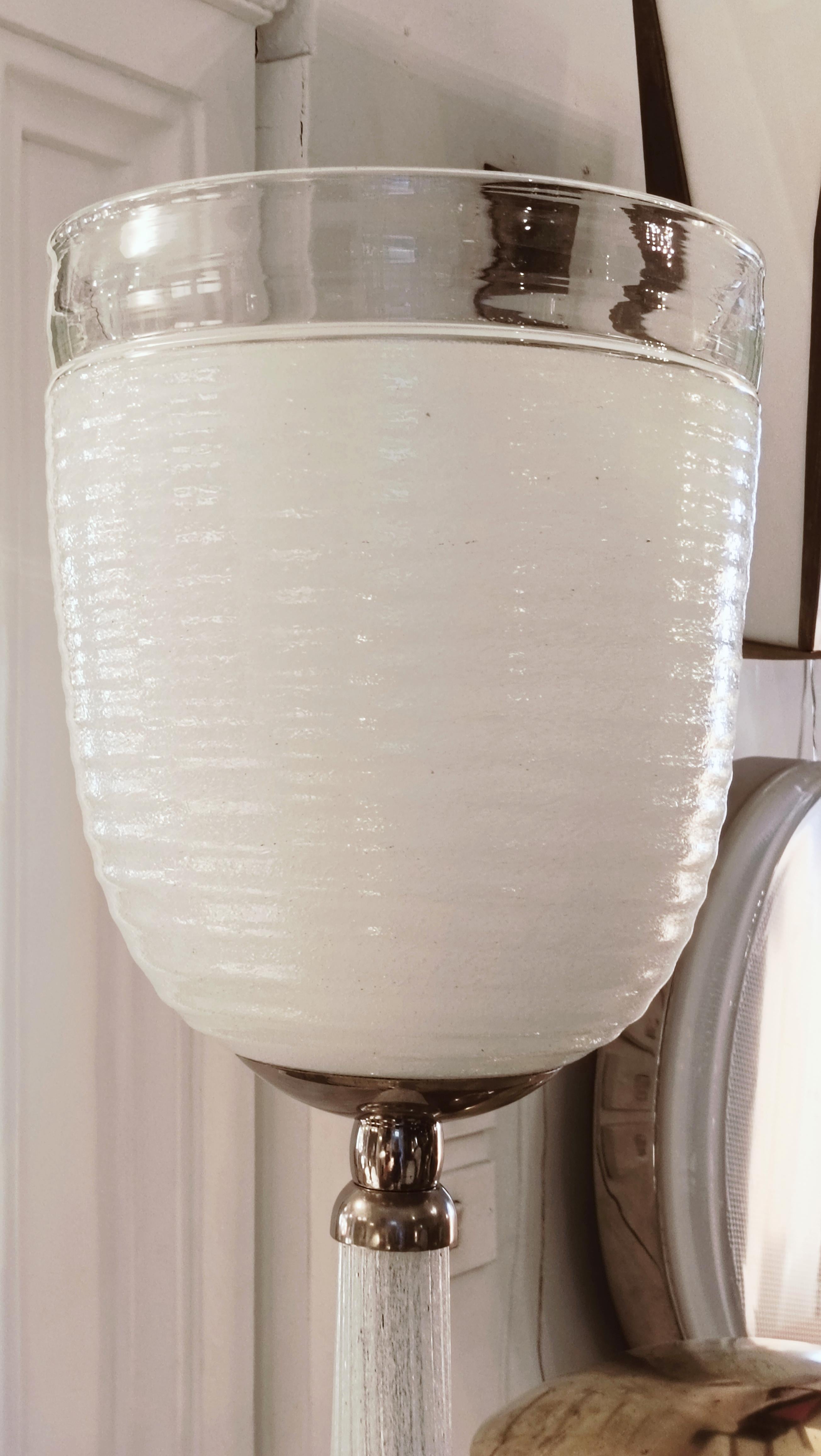 Lámpara de pie  modelo 502 de cristal de Murano diseñado por Tommaso Buzzi para la empresa Venini en 1930.
Blanco, pie y pantalla de cristal estriado transparente, base y anillos de unión de latón niquelado.Dibujos del horno nº 502 EV, 502 en el