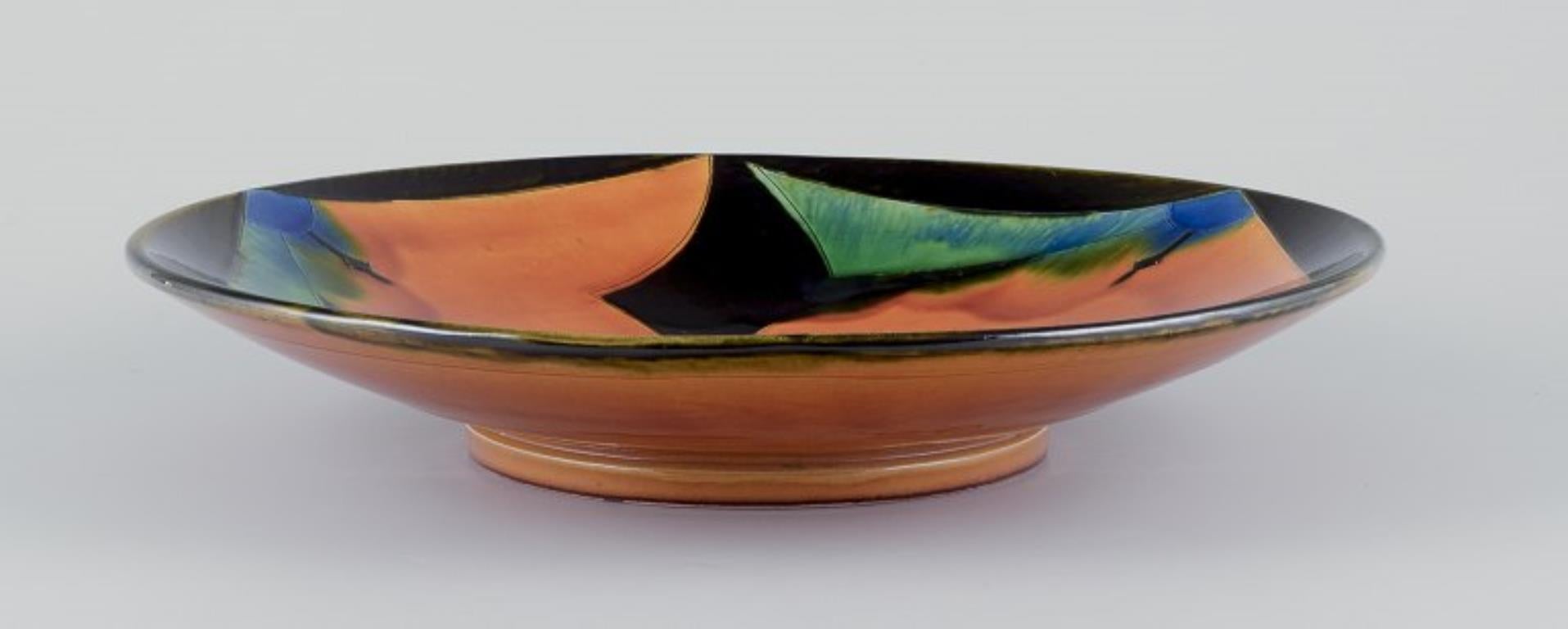 Tommerup Brickworks, Danish ceramicist.
Large ceramic bowl with polychrome glaze on a uranium yellow base.
Geometric pattern.
Hand-glazed.
In excellent condition, with natural cracks in the glaze from the manufacturing process.
Marked Tommerup