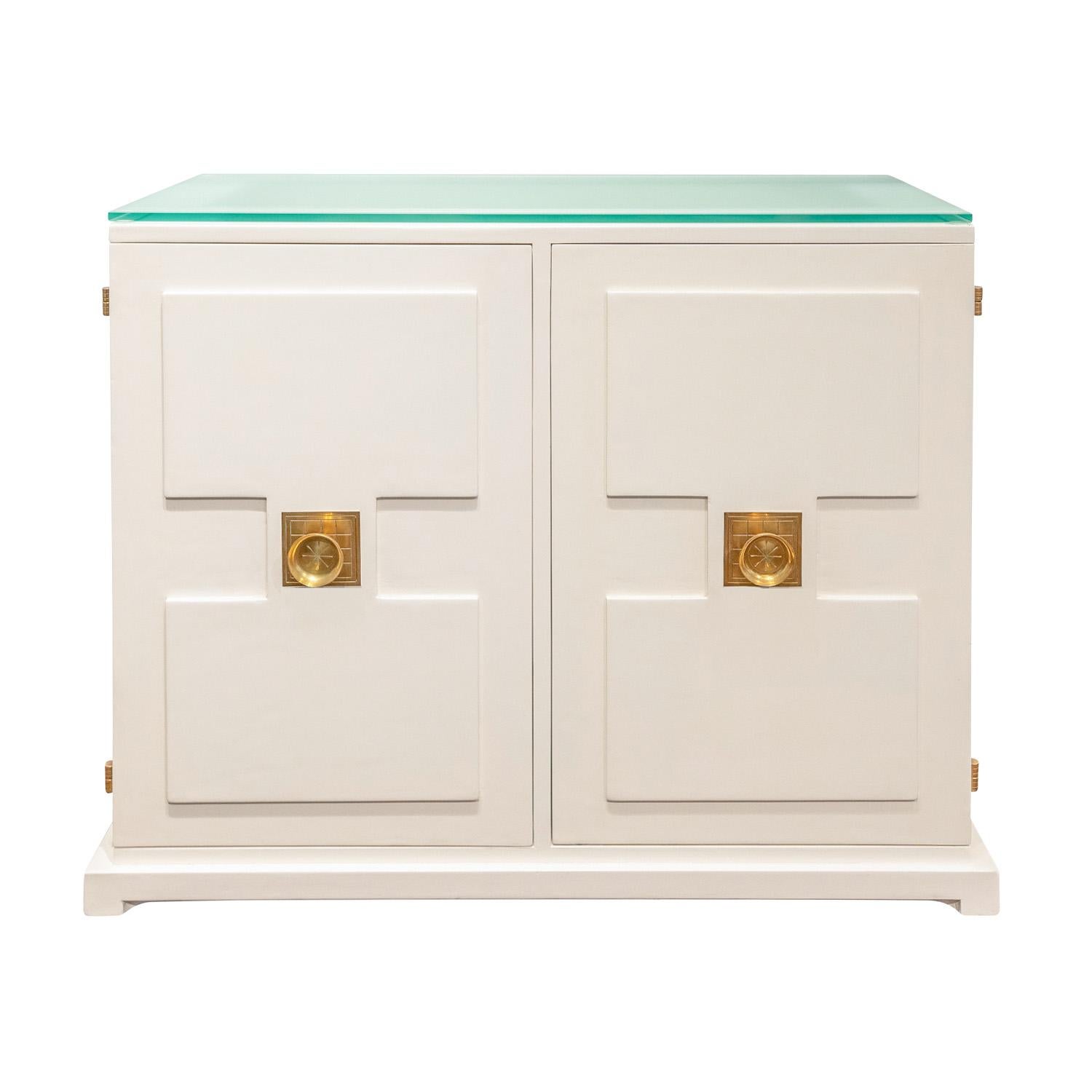 2 Door cabinet with sculpted doors and sides with geometric motif with iconic etched brass pulls and hinges, and illuminating glass top by Tommi Parzinger for Parzinger Originals, American 1960’s. This is a custom order Parzinger piece with the