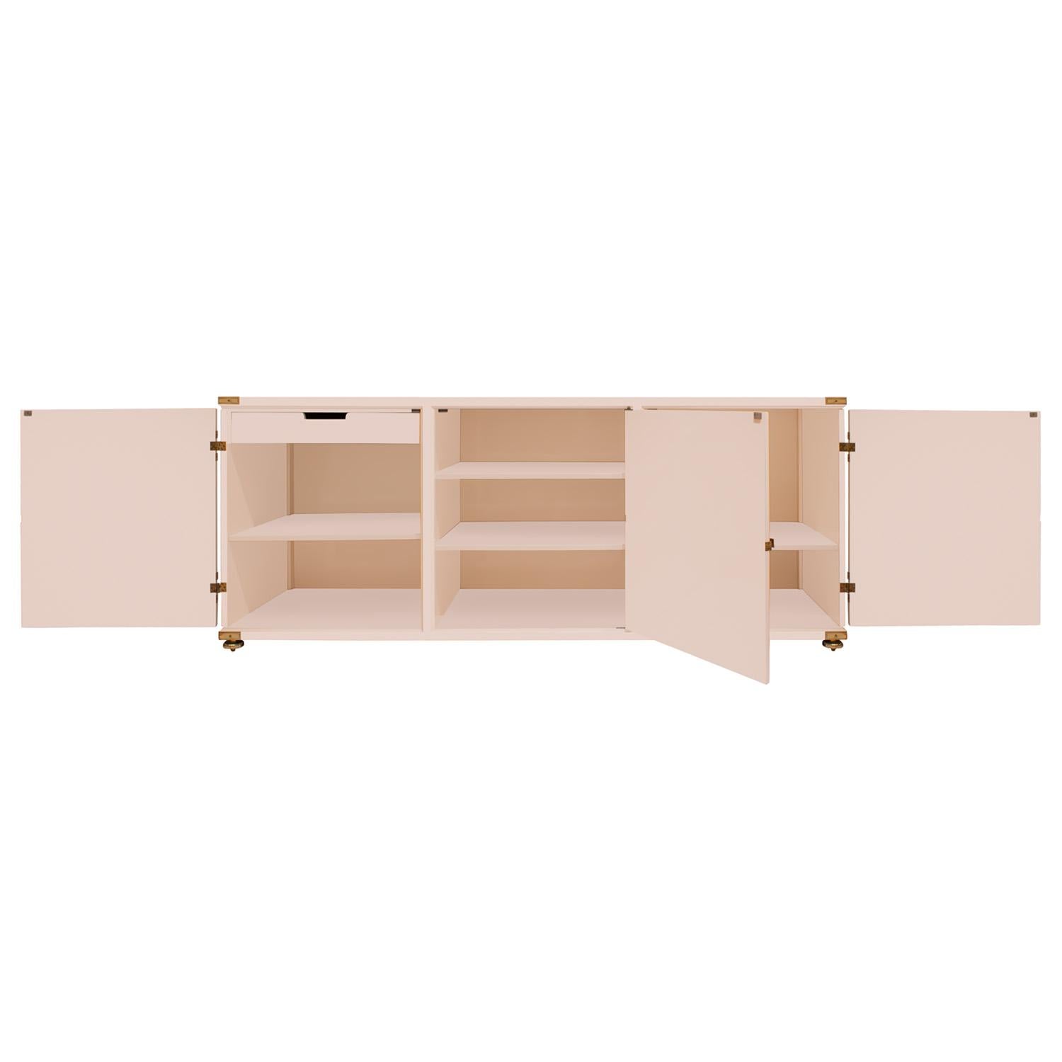 Grande ed eccezionale credenza a 3 ante modello #140 in lacca originale color crema con ferramenta in ottone squisitamente incisa, accenti angolari e piedini di Tommi Parzinger per Parzinger Originals, Stati Uniti anni Cinquanta. Gli scomparti