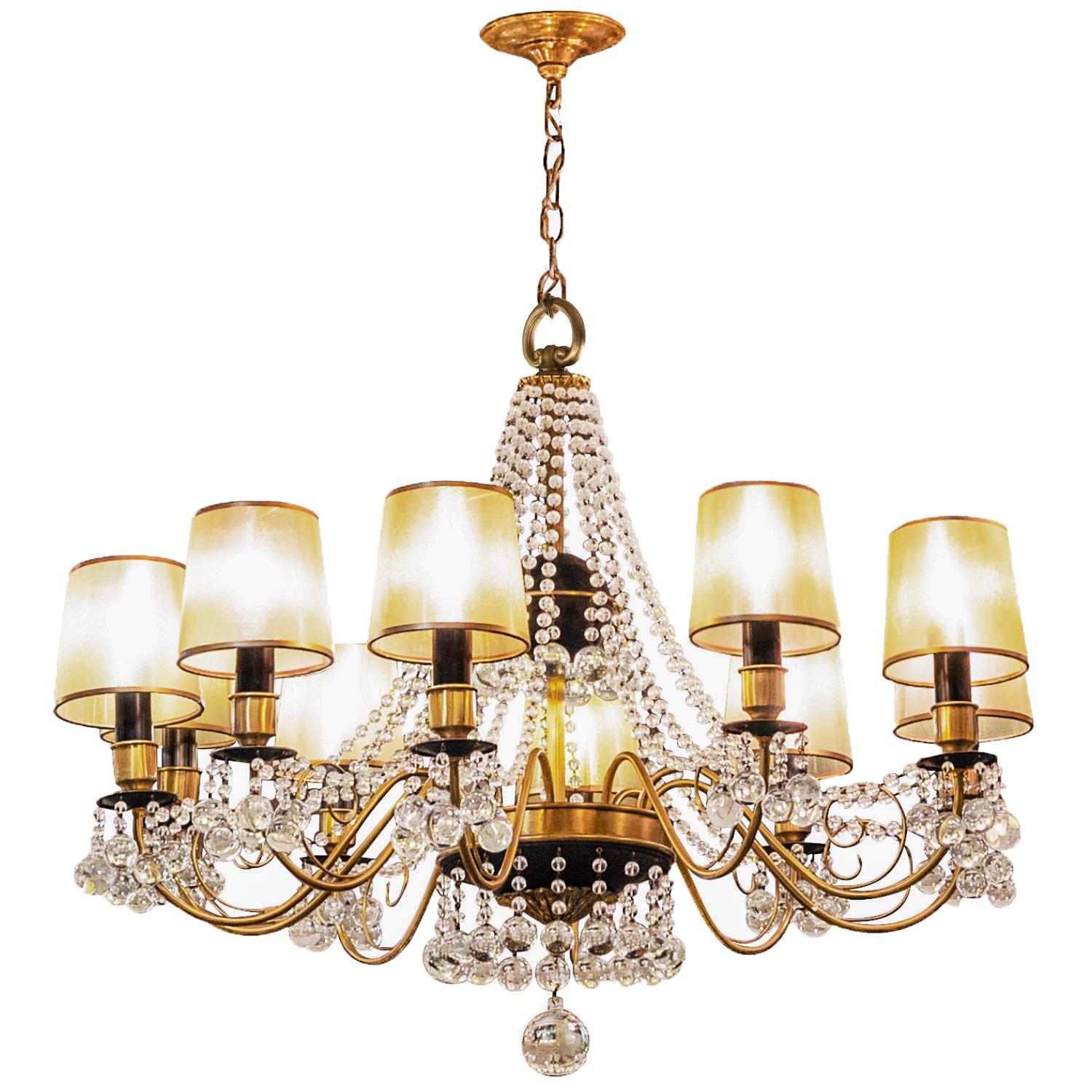 Magnificent ten arm chandelier in brass and black enamel with extensive decoration with strings of  crystals attributed to Tommi Parzinger, American 1950's.  This came from a home on Long Island that was decorated by Tommi Parzinger. This chandelier