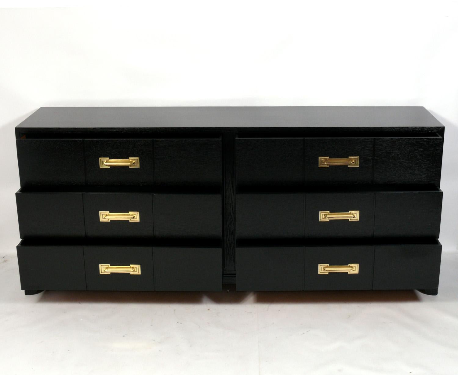 Elegant midcentury chest, designed by Tommi Parzinger for Charak Modern, American, circa 1950s. It has been completely restored, refinished in black lacquer and the brass hardware hand polished and lacquered. It is a versatile Size and can be used