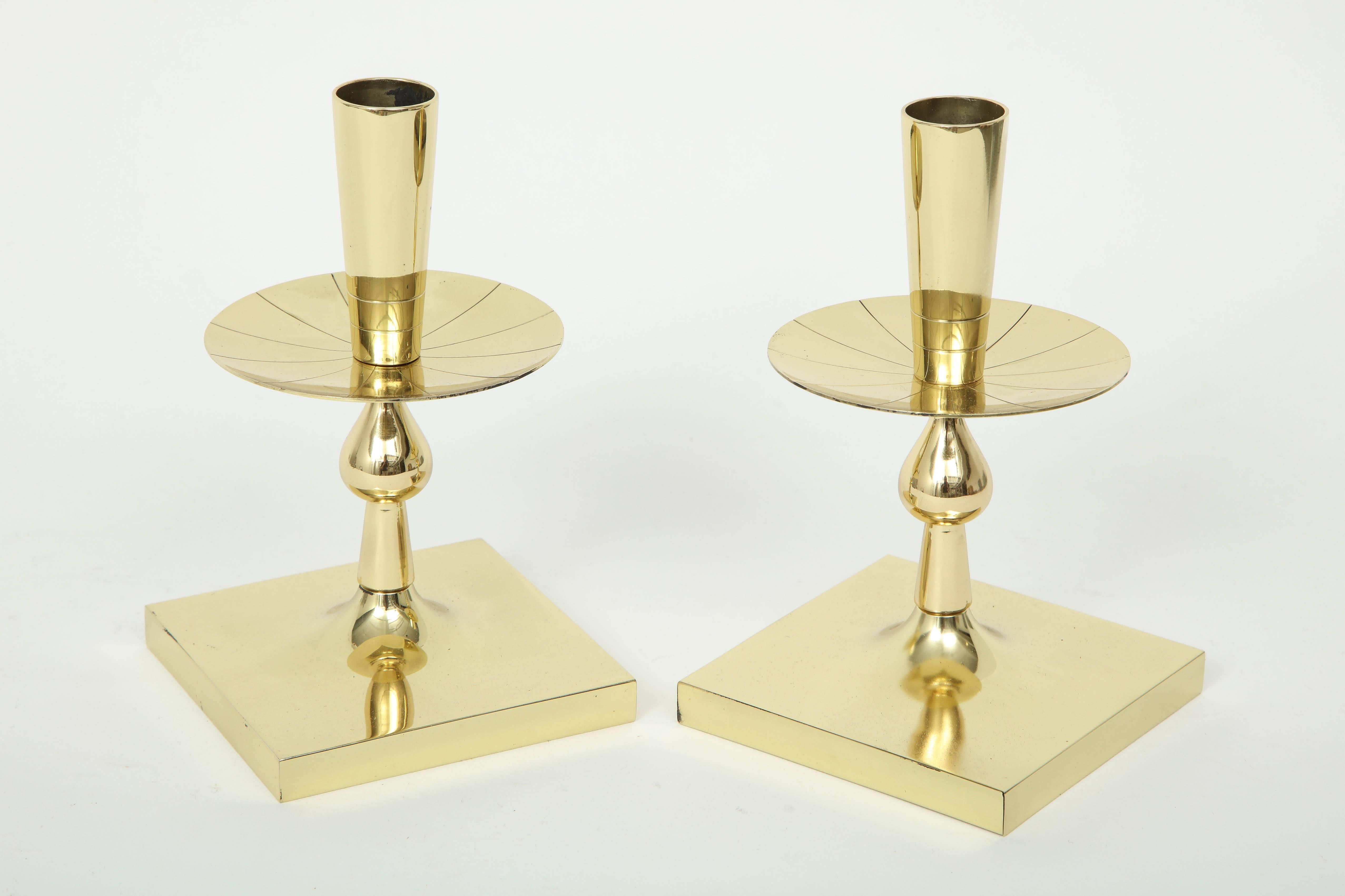 Pair of midcentury classically styled candlesticks with a square base stylized column and engraved drip plate. Designed by Tommi Parzinger, signature stamp on bottom. Polished.