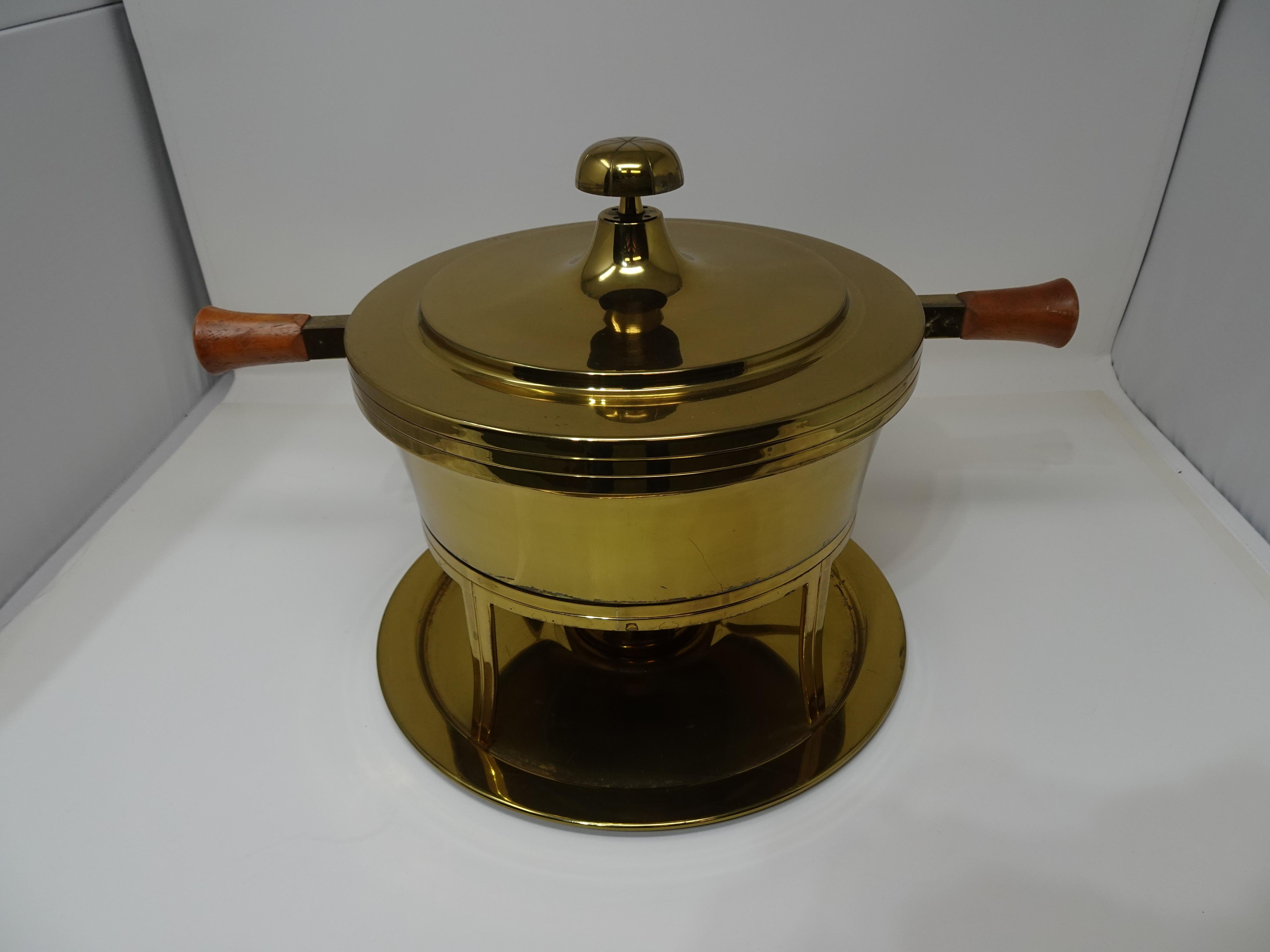 A nice Parzinger chaffing dish containing six pieces the lid with wood handles topped with a mushroom knob , body having the rare inner Pyrex glass insert, matching stand, burner and tray. Retains the manufactures imprint to bottom plate by Dorlyn