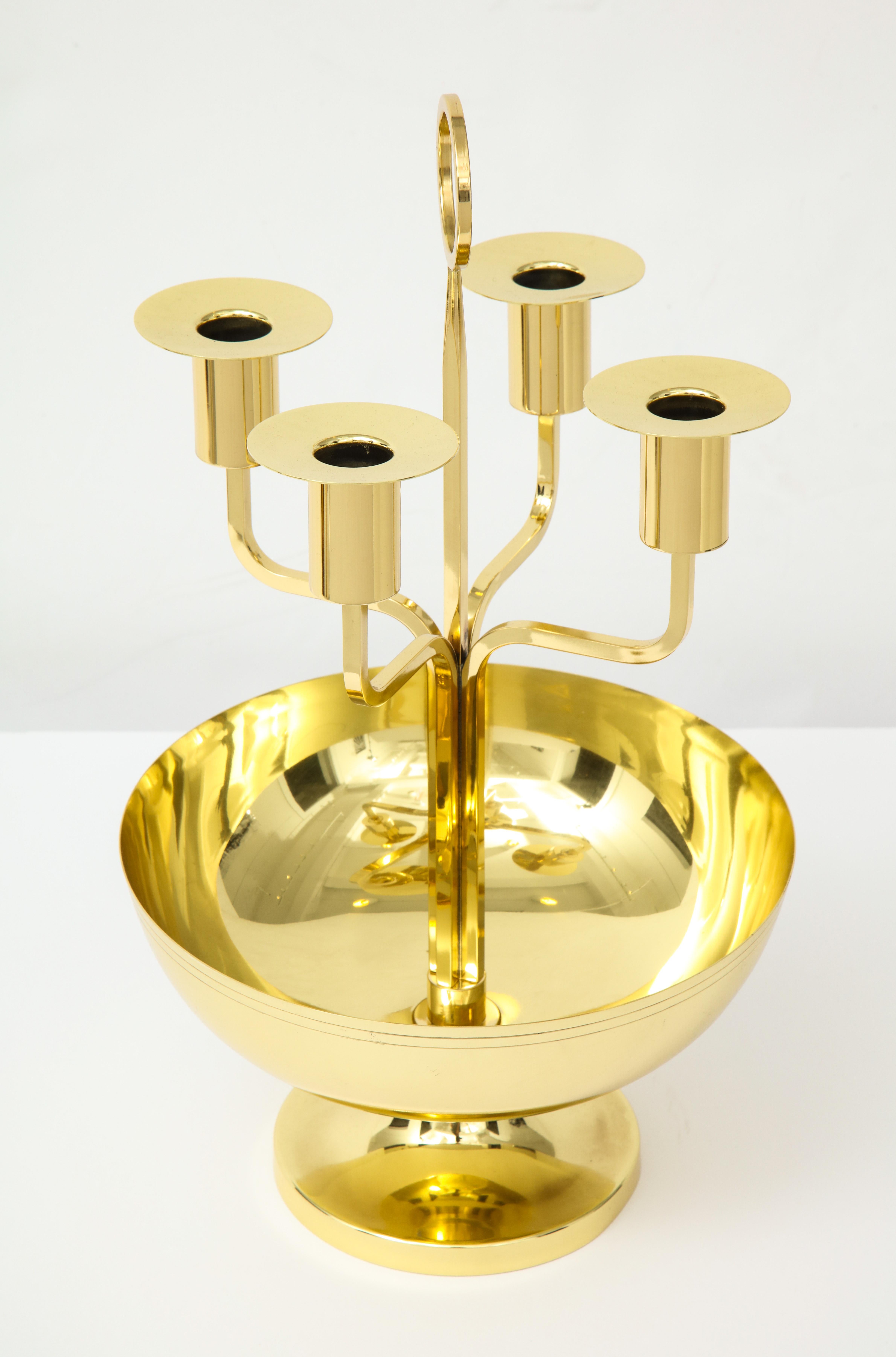 Polished brass centrepiece featuring a shallow bowl for flowers and 4 candleholders. Engraved parallel pinstripe detail around the perimeter of the bowl. Tommi Parzinger for Dorlyn. Professionally polished and lacquered.