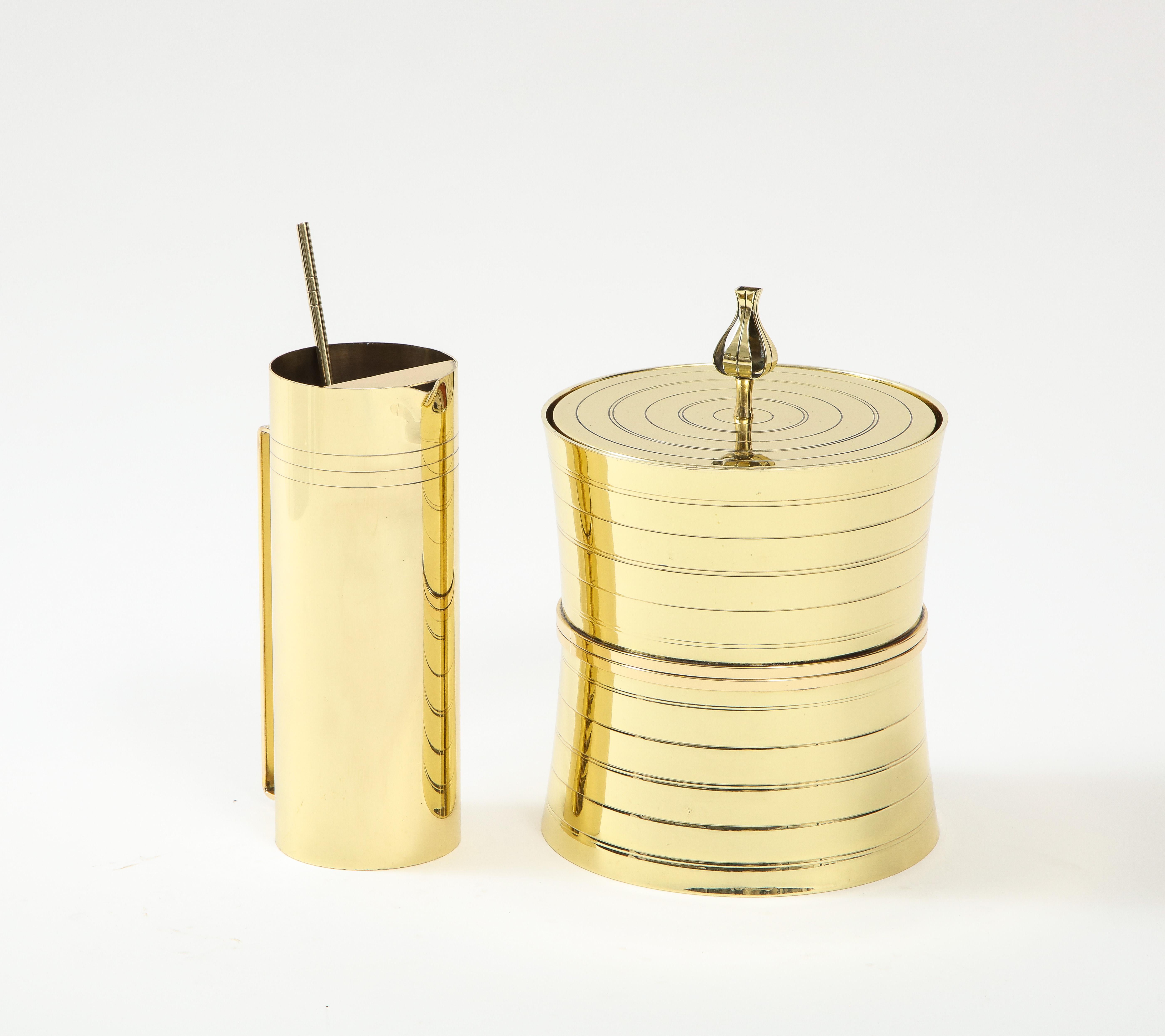 Modernist Tommi Parzinger brass ice bucket and martini pitcher with stirrer, both featuring engine turned pinstripe details. Stamped. Ice Bucket retains its original Mercury Glass Thermos liner.

Ice Bucket measures 7.5
