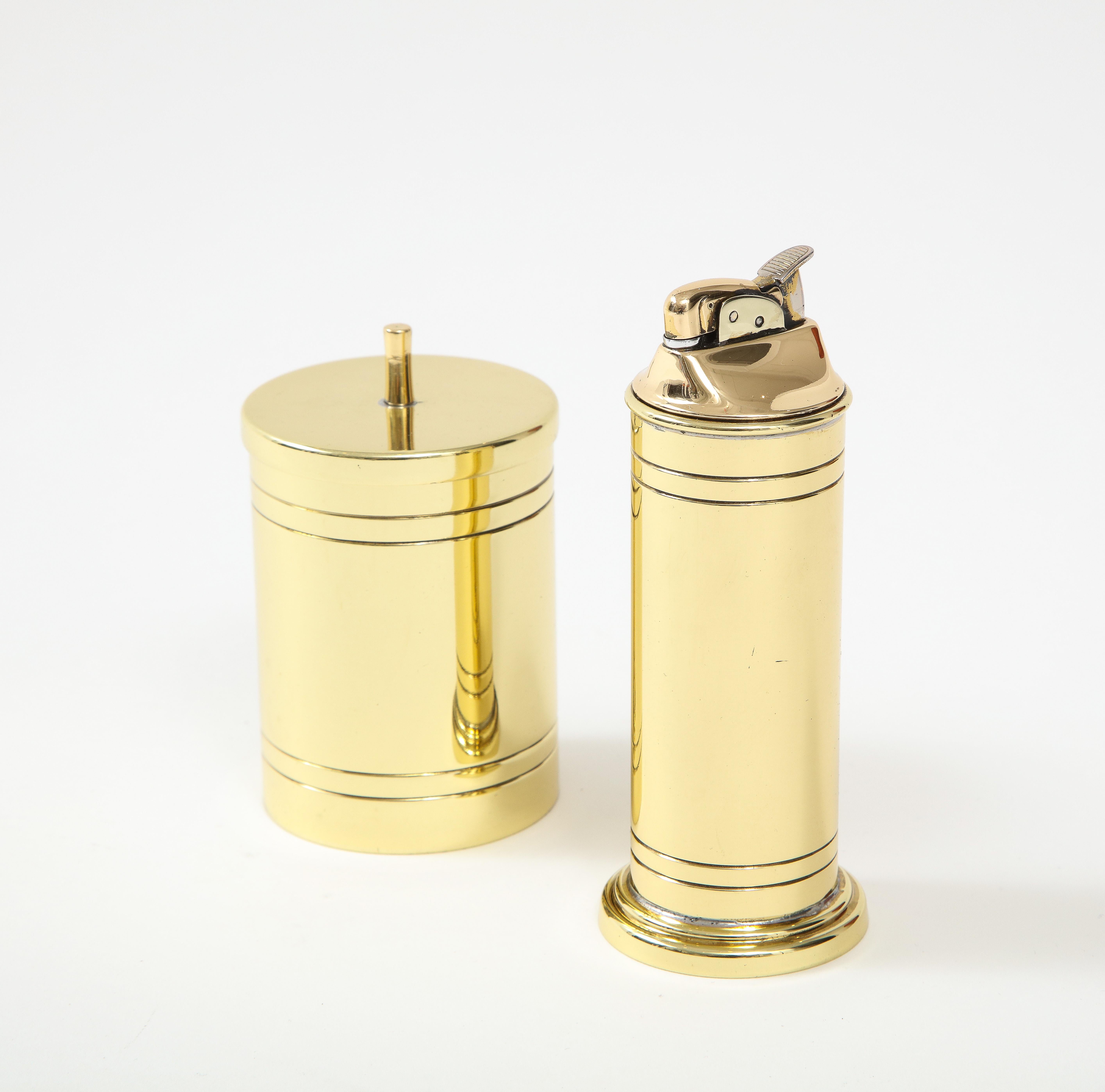 Seldom seen Tommi Parzinger brass smoking set includes brass lighter and cigarette/tobacco canister both with engine turned pinstripes. Signed. Lighter will need fluid and flint.

Lighter Measures 5.25