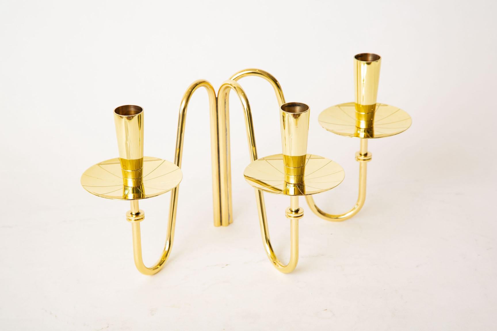 This solid brass 3 arm candlestick by Tommi Parzinger is Mid-Century Modern. It has been professionally polished. It is still modern today. Simplicity of lines with elegance. From the 50's. Good weight.