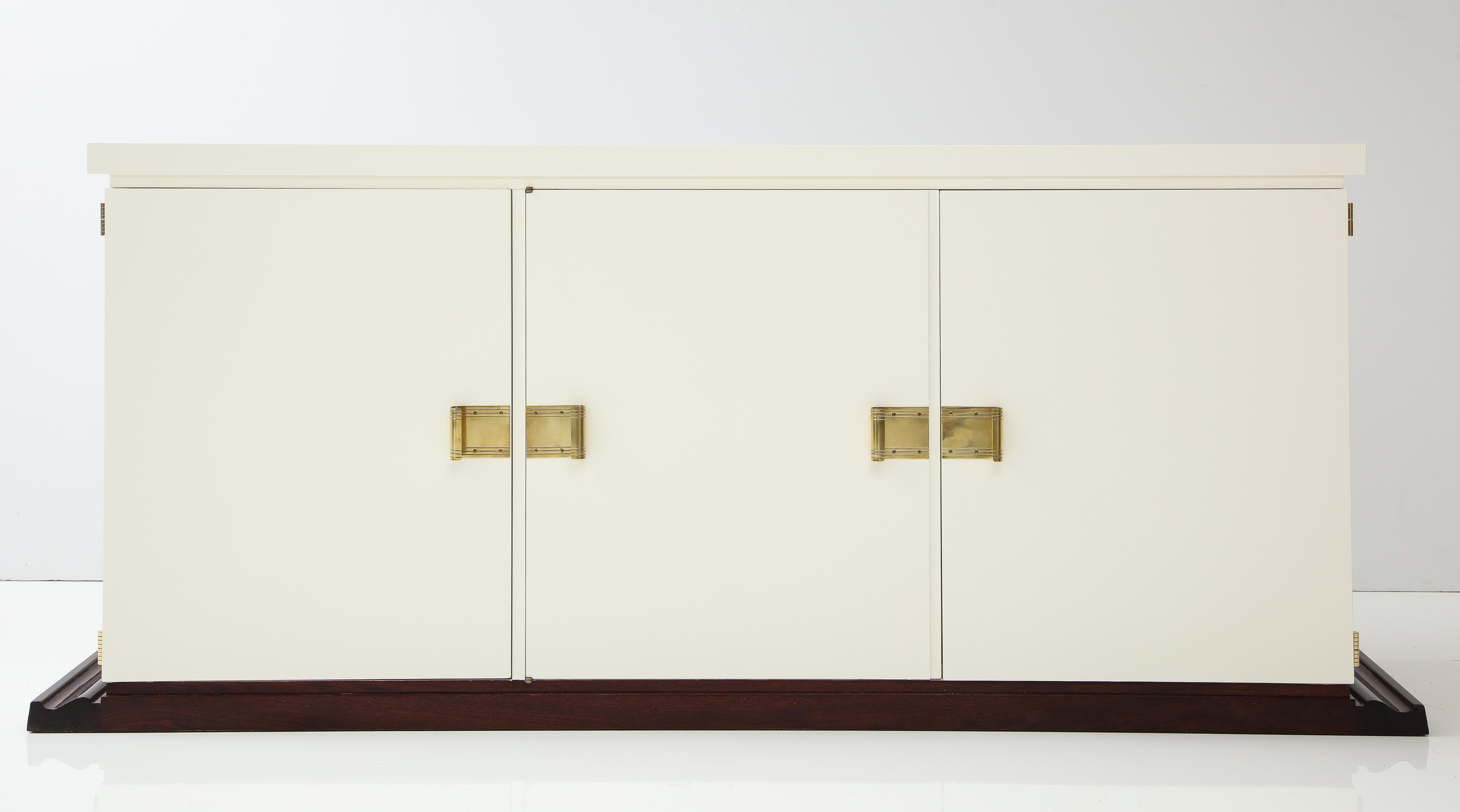 Stunning Tommi Parzinger cabinet.
Sleek sophisticated cabinet Newly restored in an ivory satin finish set on a rich Mahogany plinth base.
The cabinet has two sets of drawers with the left side having four smaller and the right side having four