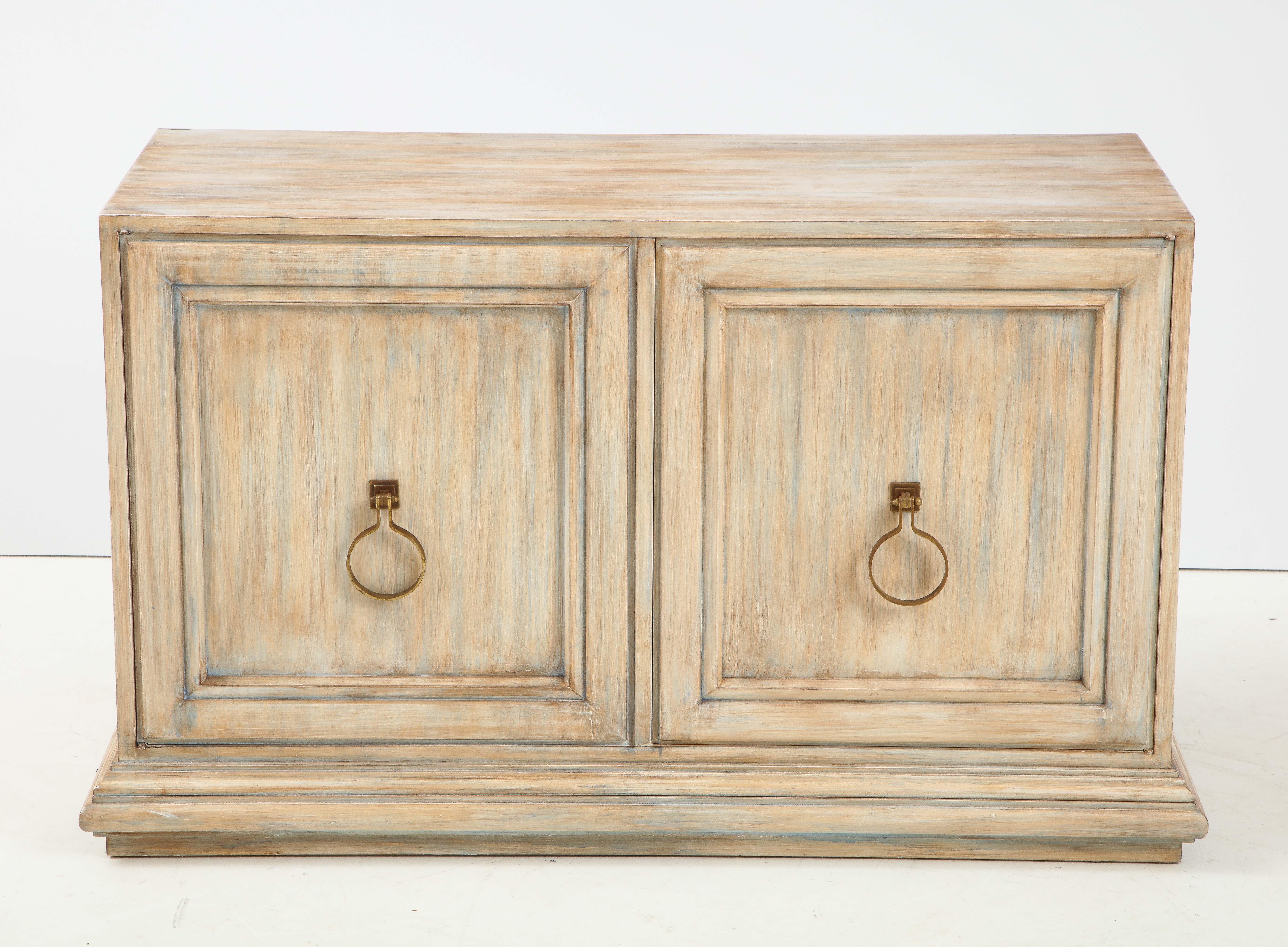 Mid-Century Modern cabinet featuring the original driftwood finish and brass door knocker hardware. Cabinet provides ample storage with 1 adjustable shelf.