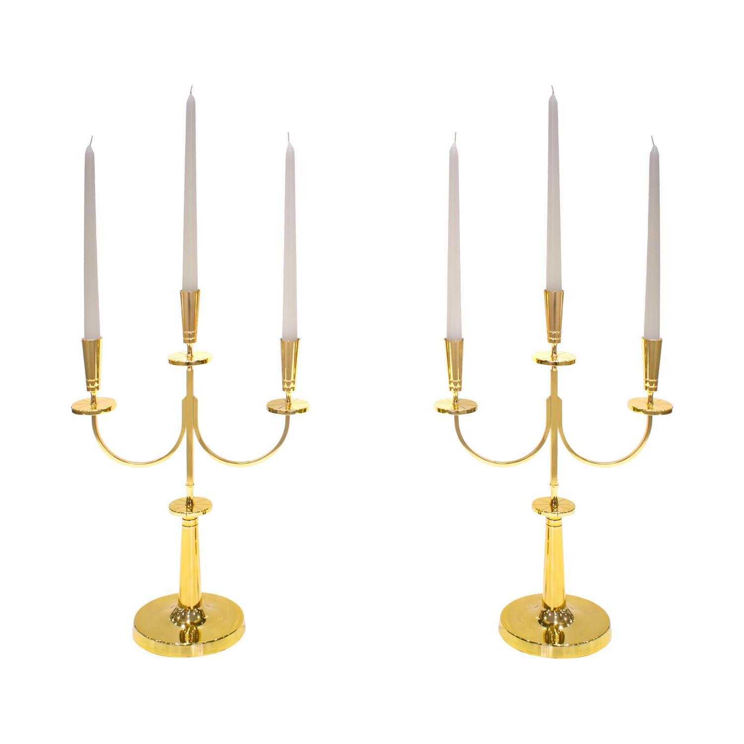 Pair of elegant three stick candelabra in polished brass by Tommi Parzinger for Dorlyn Silversmiths, American 1950's (signed on bases “Dorlyn Silversmiths”). Each engraved with Parzinger’s iconic radiating lines. Newly polished and lacquered by