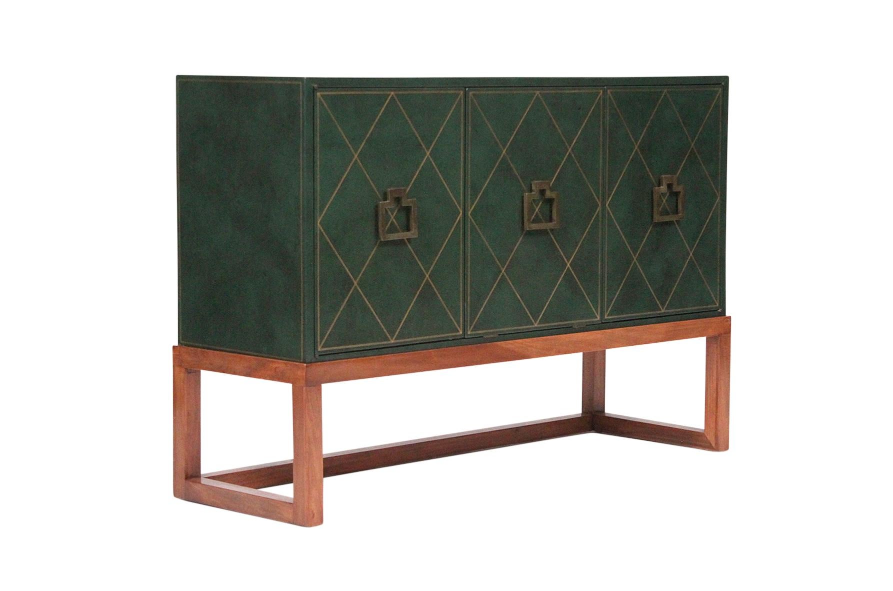 Tommi Parzinger for Charak Modern three leather-clad cabinet. Leather finish tooled and gilded in a diamond pattern. Three sections featuring coral pink interior. Two side doors conceal shelving while center door drops to reveal two drawers in