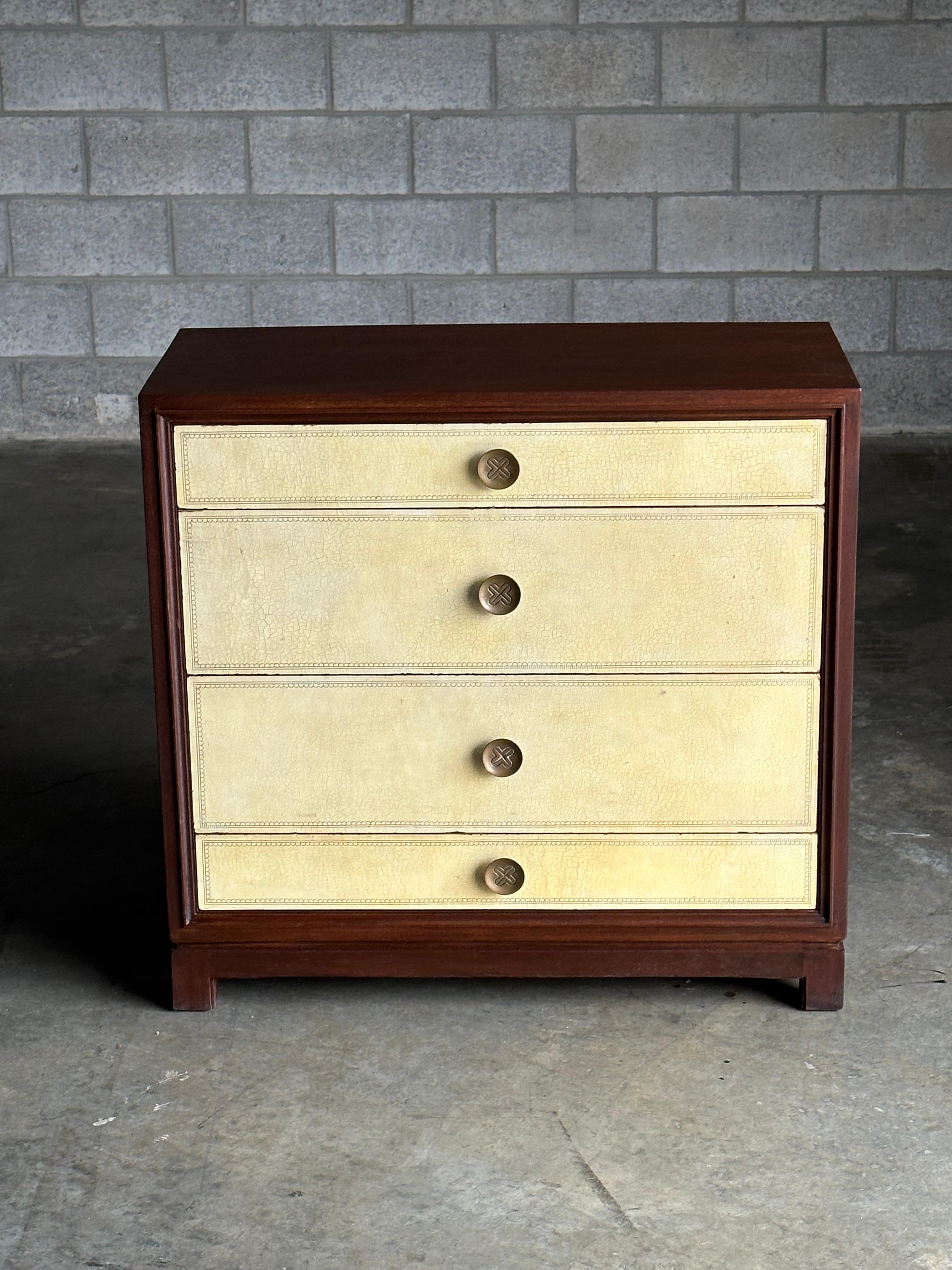 An elegant chest of drawers designed by Tommi Parzinger for Charak Modern. Drawer fronts feature hand tooled yellow/ parchment leather which perfectly compliments the dark wood case. 

The well proportioned size makes for uses throughout many