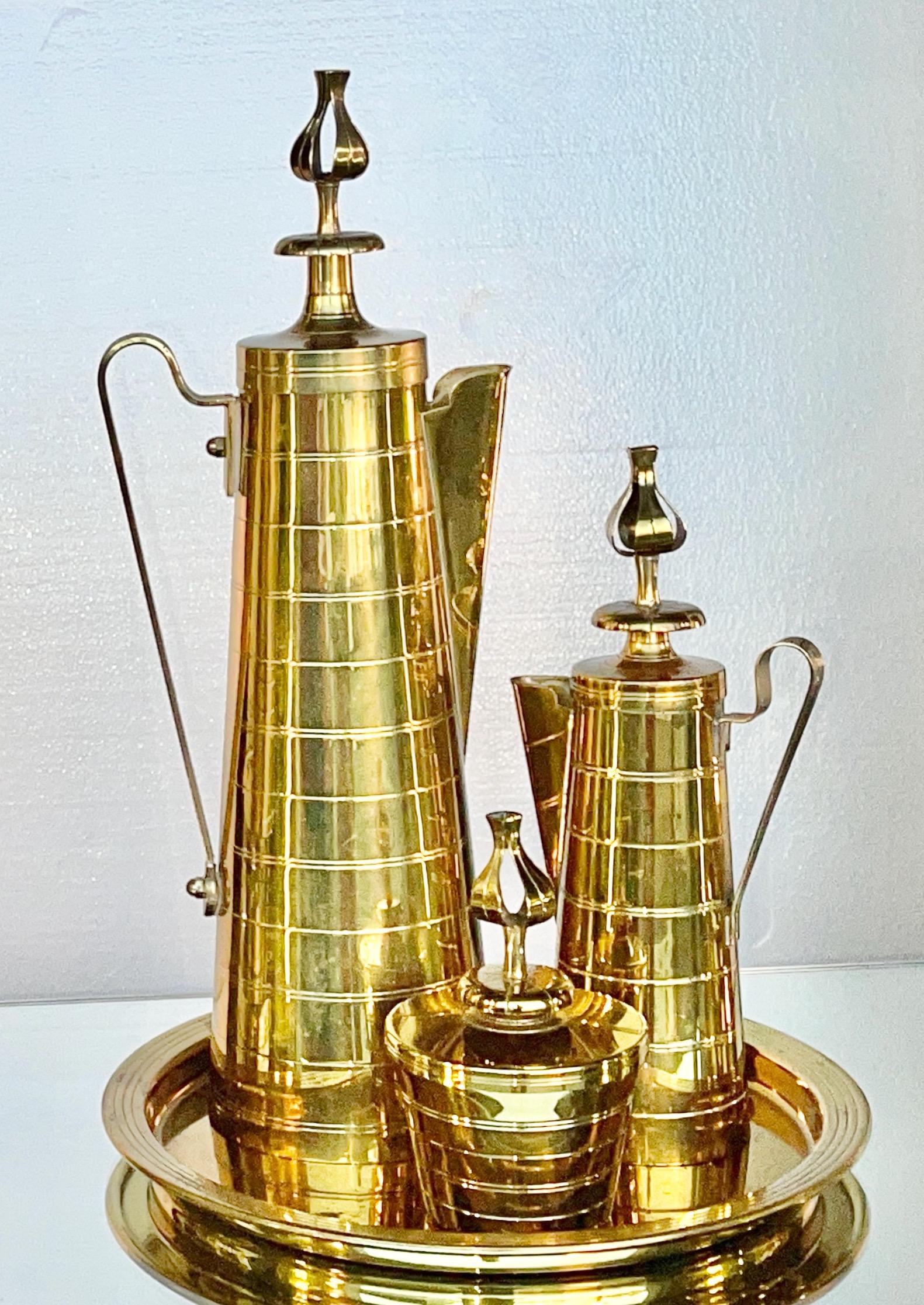 Four piece coffee/tea service in solid brass designed by Tommi Parzinger for Dorlyn Silversmiths circa 1950, distributed by Vincent Lippe Co.
This is the earliest version with the distinctively ornate thistle finials on the fitted lids.
Set includes