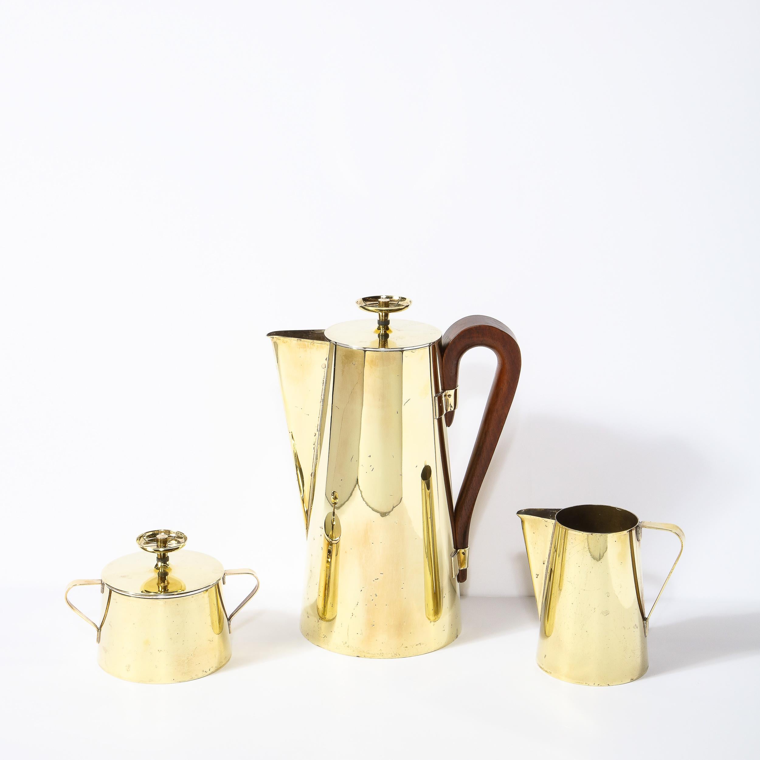 This gorgeous coffee or tea service set was designed by Tommi Parzinger, among the most celebrated Mid-Century Modernist designers, for Dorlyn Silversmiths circa 1960. The set includes one tea pot, a creamer, and a sugar bowl with lid. The service