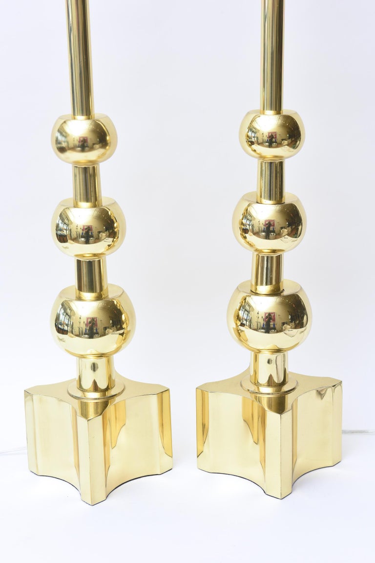 These fabulous newly brass-plated Tommi Parzinger for Stiffel Lamp Co. pair of Mid-Century Modernist ball lamps are timeless. They are from the late 1950s or early 1960s. They have been rewired and do not come with shades or harps. The tall base is