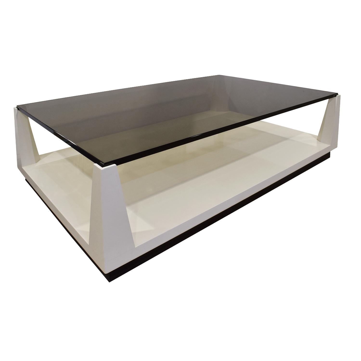 Lacquered coffee table with raised smoked glass top by Tommi Parzinger for Parzinger Originals, American 1970's. This came from an apartment decorated by Donald Cameron, Tommi Parzinger’s business and life partner. It is on hidden castors.