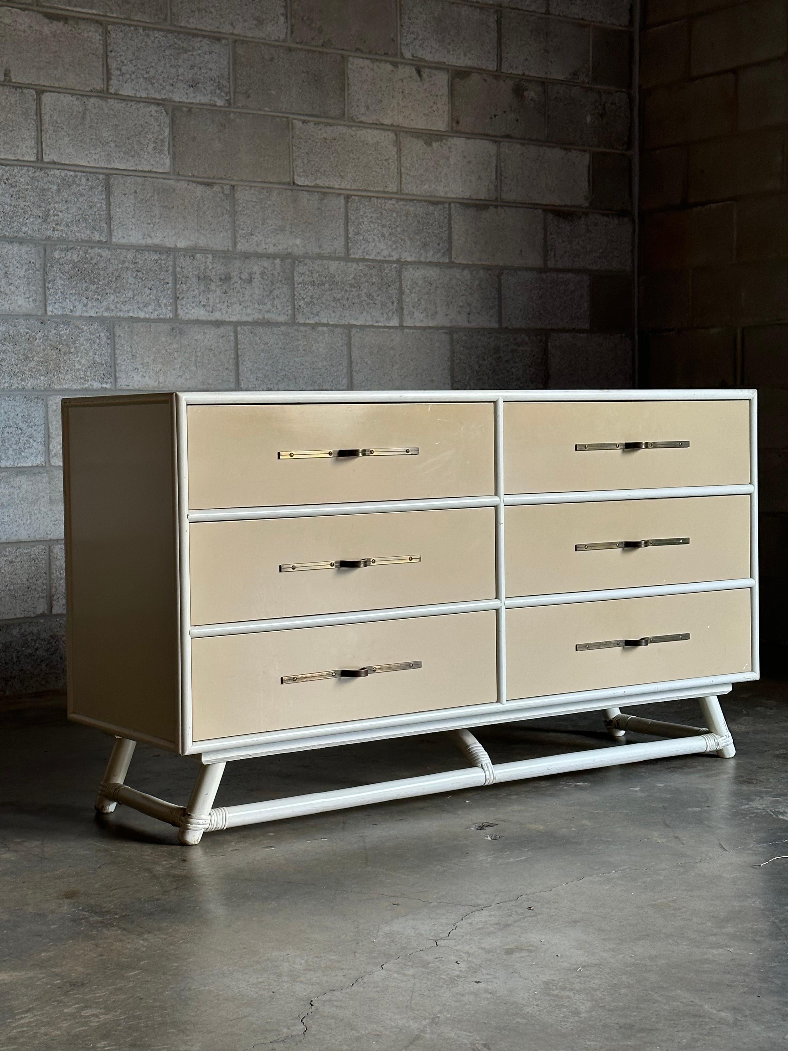 A rare dresser designed by Tommi Parzinger. This example appears to be in original condition with white exterior and tan drawer fronts, complete with fashionable drawer pulls so characteristic of Parzinger’s more common designs. There are 6 spacious