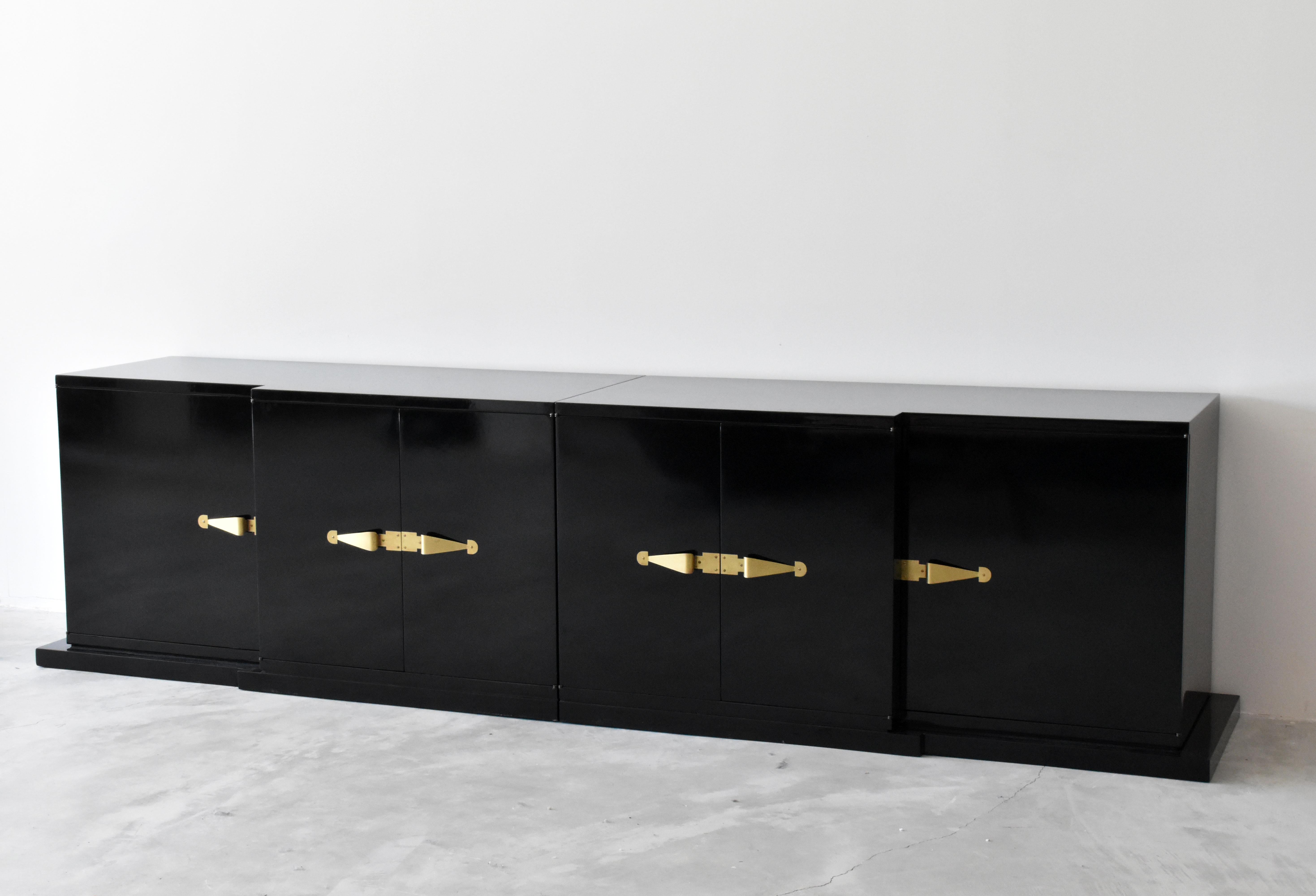 A large cabinet or credenza or sideboard in two sections. Crafted in Tommi Parzingers American studio, Tommi Parzinger Originals. Contrasting the black lacquered surface are four brass pulls. Black lacquered inside.

Other American designers of the