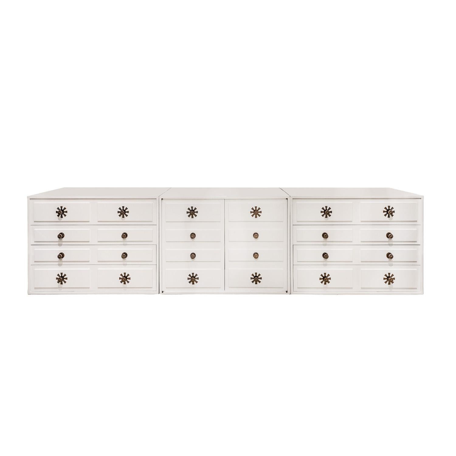 Rare and exceptional long cabinet in white lacquer with bronze stylized flower pulls by Tommi Parzinger for Parzinger Originals, American 1950s (signed “Parzinger Originals” on inside of drawer).  There is 1/2 inch high recessed base.  Chests on