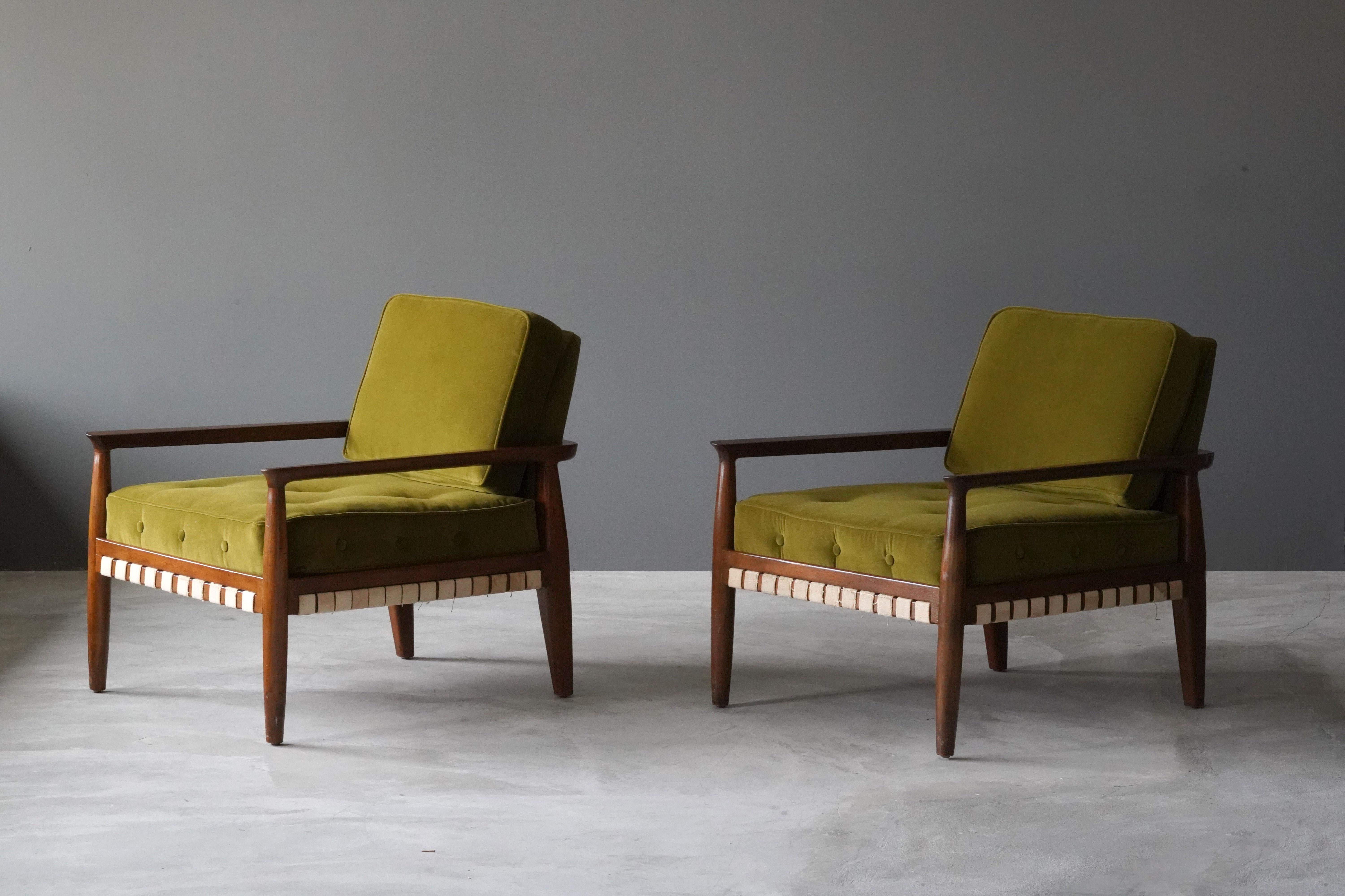 A pair of lounge chairs designed by Tommi Parzinger in 1957. Produced by Charak Modern. Composed of stained walnut, original webbing, cushions reupholstered in brand new high-end velvet. 

