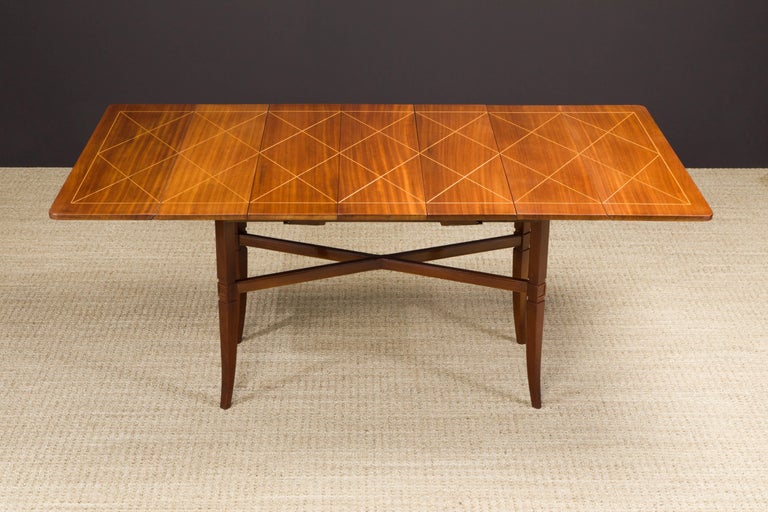 A rare collectors item with innovative technology and design, this Tommi Parzinger for Charak Furniture Company Mahogany table crafted in circa 1951 features geometric fruitwood inlay on top of squared tapered legs, a drop leaf and rotating design