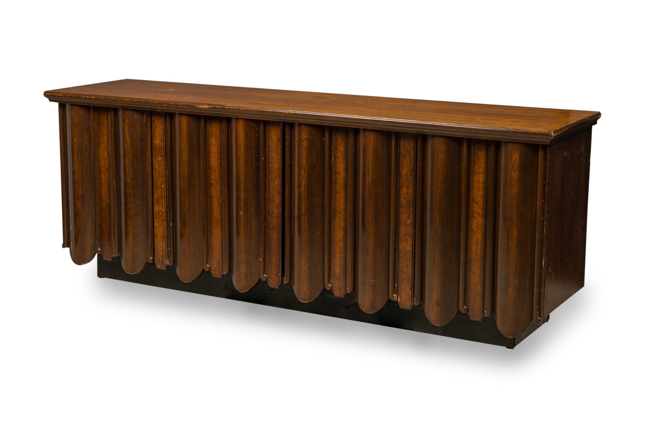 Mid-Century Continental credenza features a beveled top, 4 sculpted front doors opening to reveal 3 columns of 3 pullout drawers, resting on a rectangular base. (TOMMI PARZINGER)
 

 Wear to finish, minor losses to wood at bottom of doors
