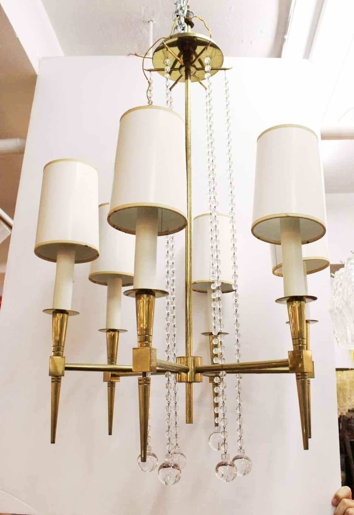 Tommi Parzinger Mid-Century Modern solid brass and glass beaded six-light chandelier with its original linen shades, made in the 1950's.
