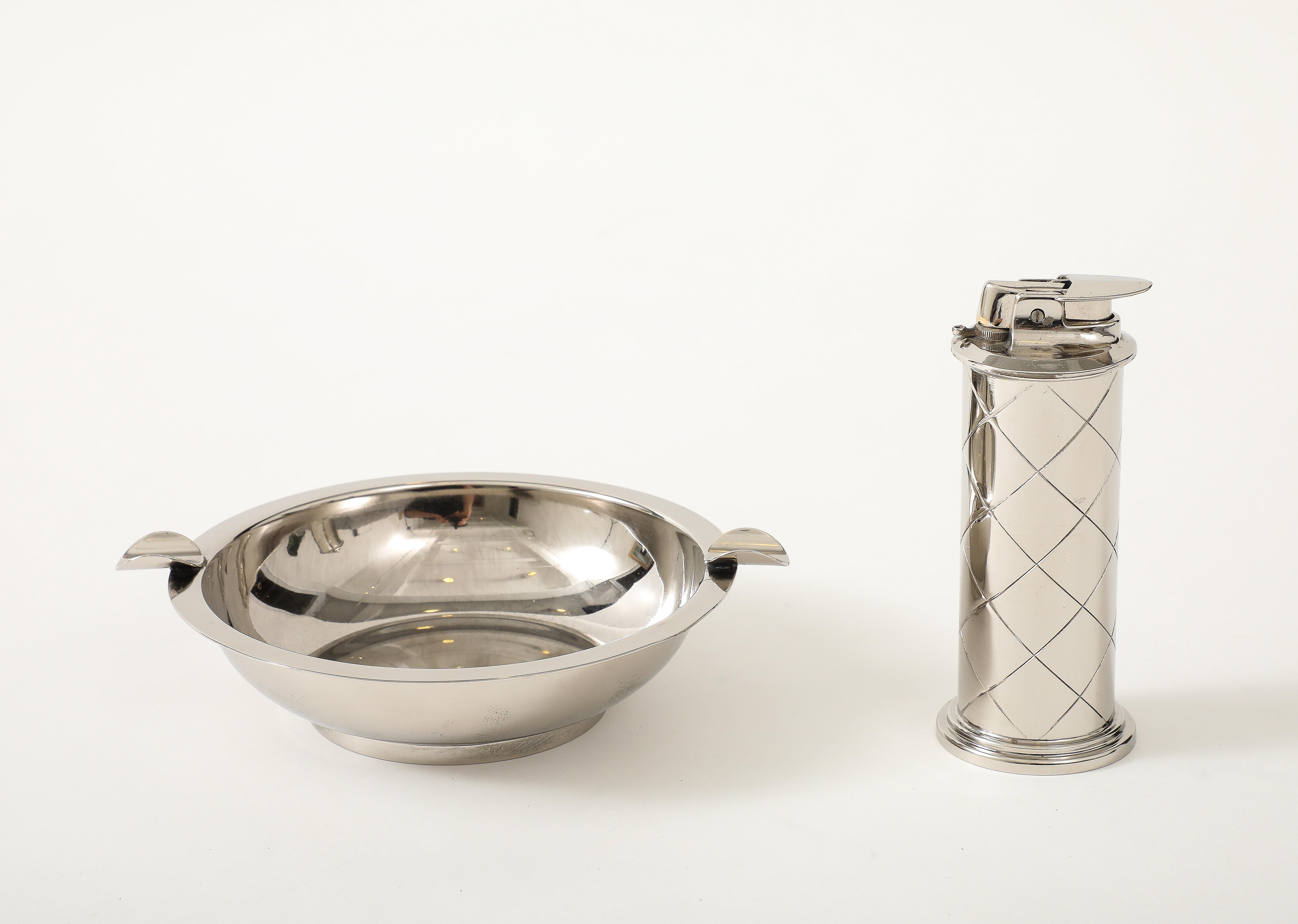 Mid Century polished nickel smoking set featuring an ashtray and lighter with an etched diamond pattern, Signed.


Lighter measures 5