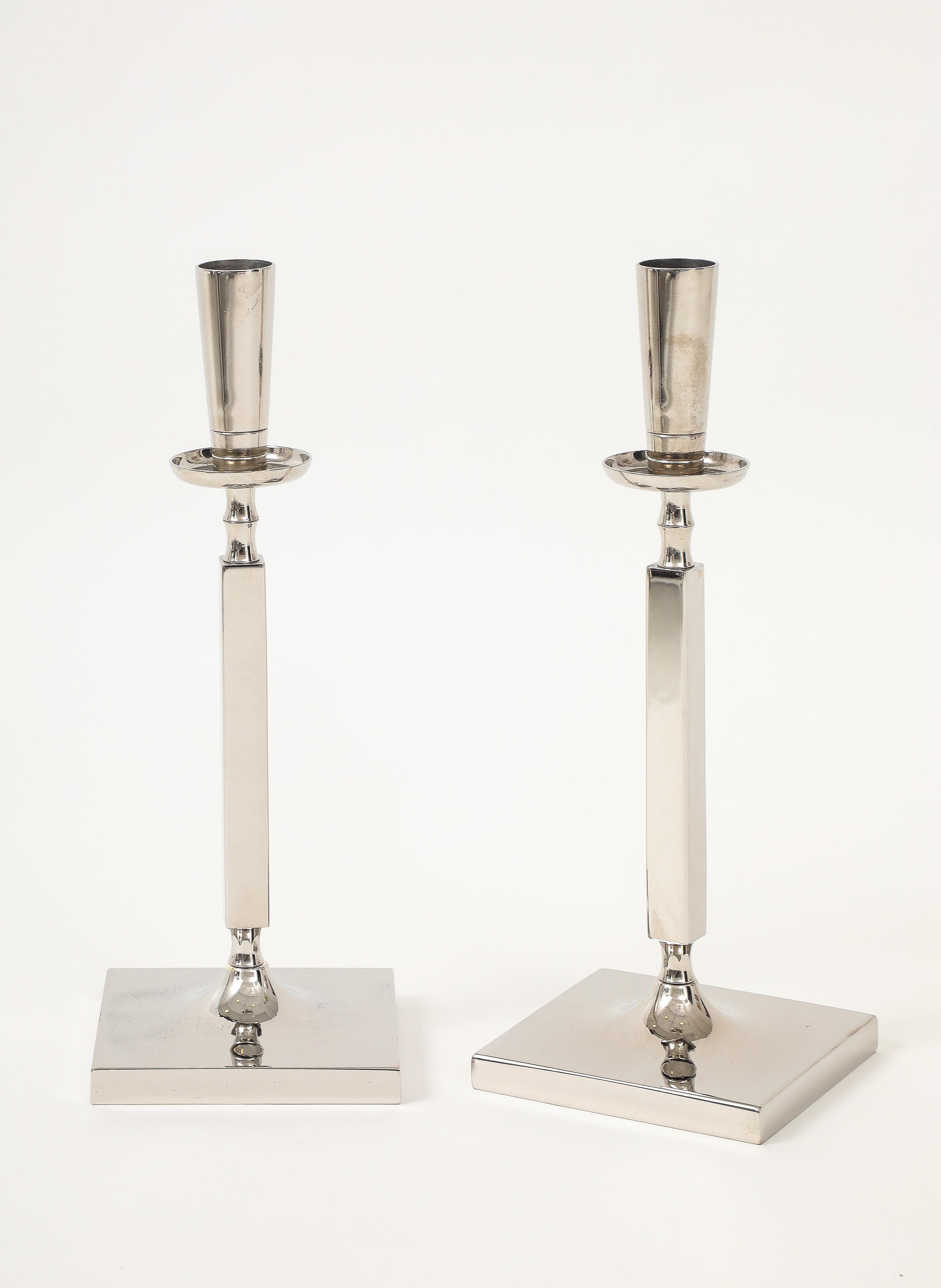 Elegante coppia di candelabri a colonna in nichel lucido della metà del secolo scorso, disegnati da Tommi Parzinger.