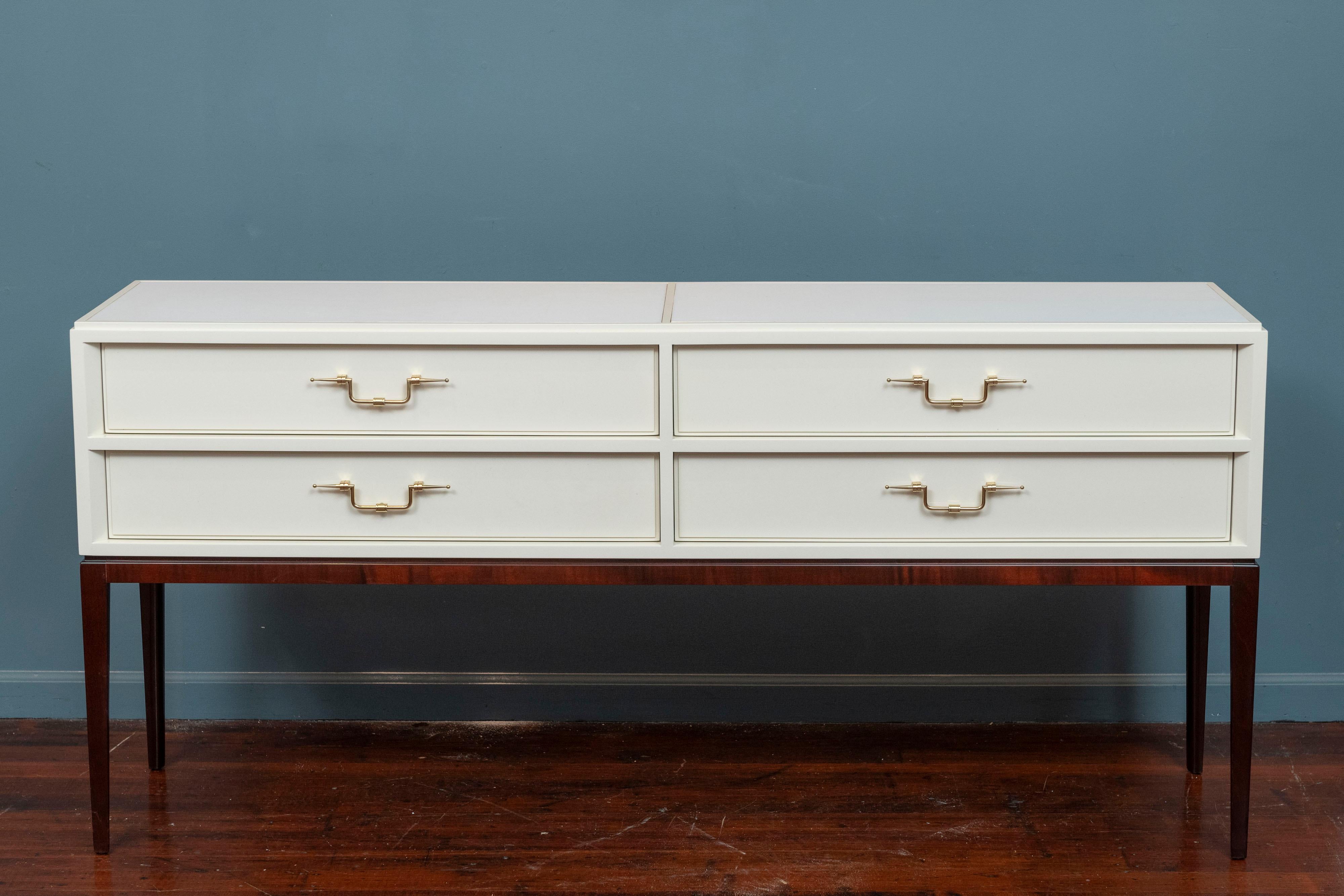 Tommi Parzinger Originals console table or small credenza. Sophisticated modernism executed in Spanish white lacquer on a dark mahogany stained base with polished brass hardware. Featuring four large drawers and two inset milk glass sections in the